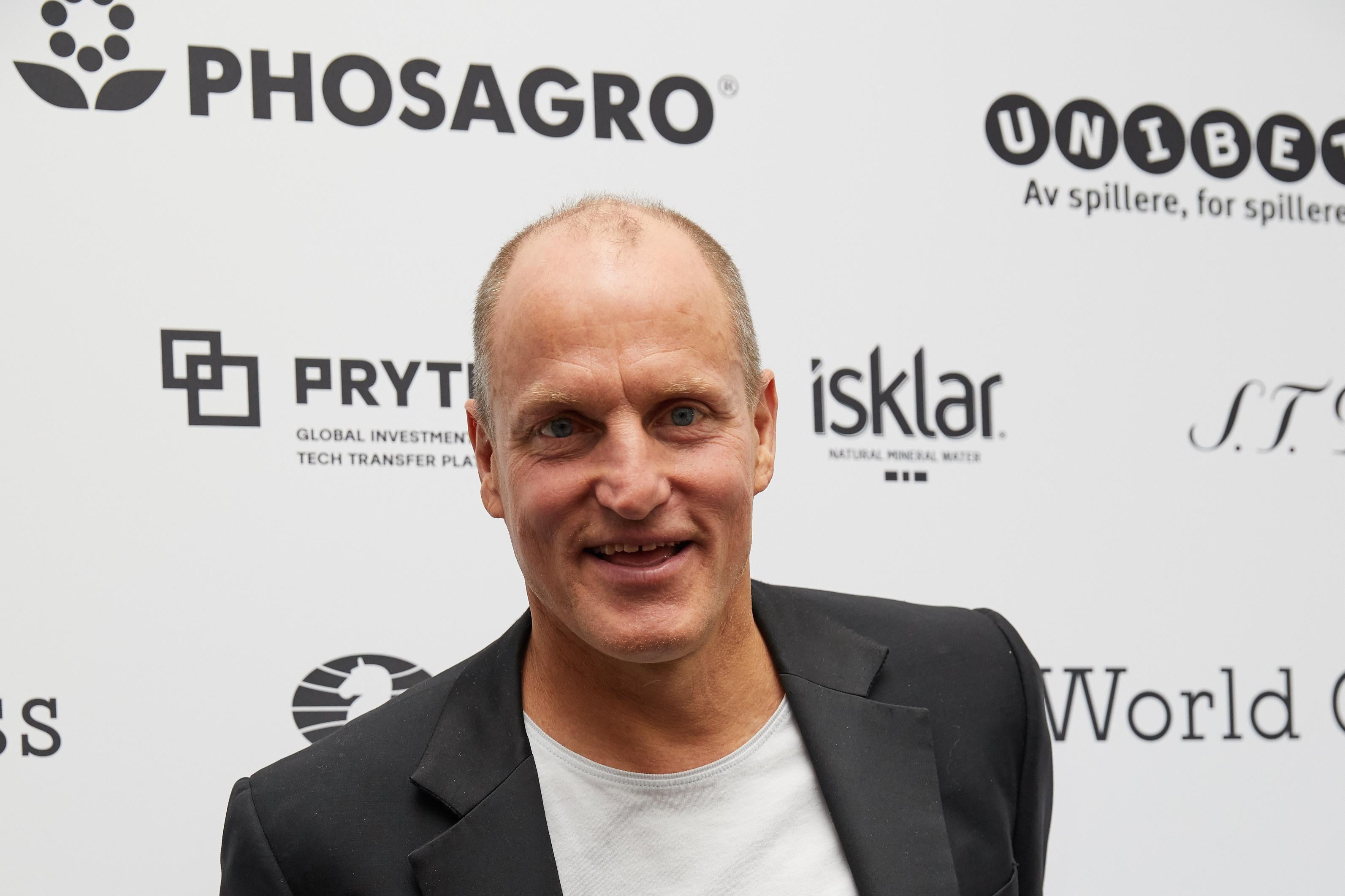 Woody Harrelson attends smiles, wearing a white shirt and black suit.