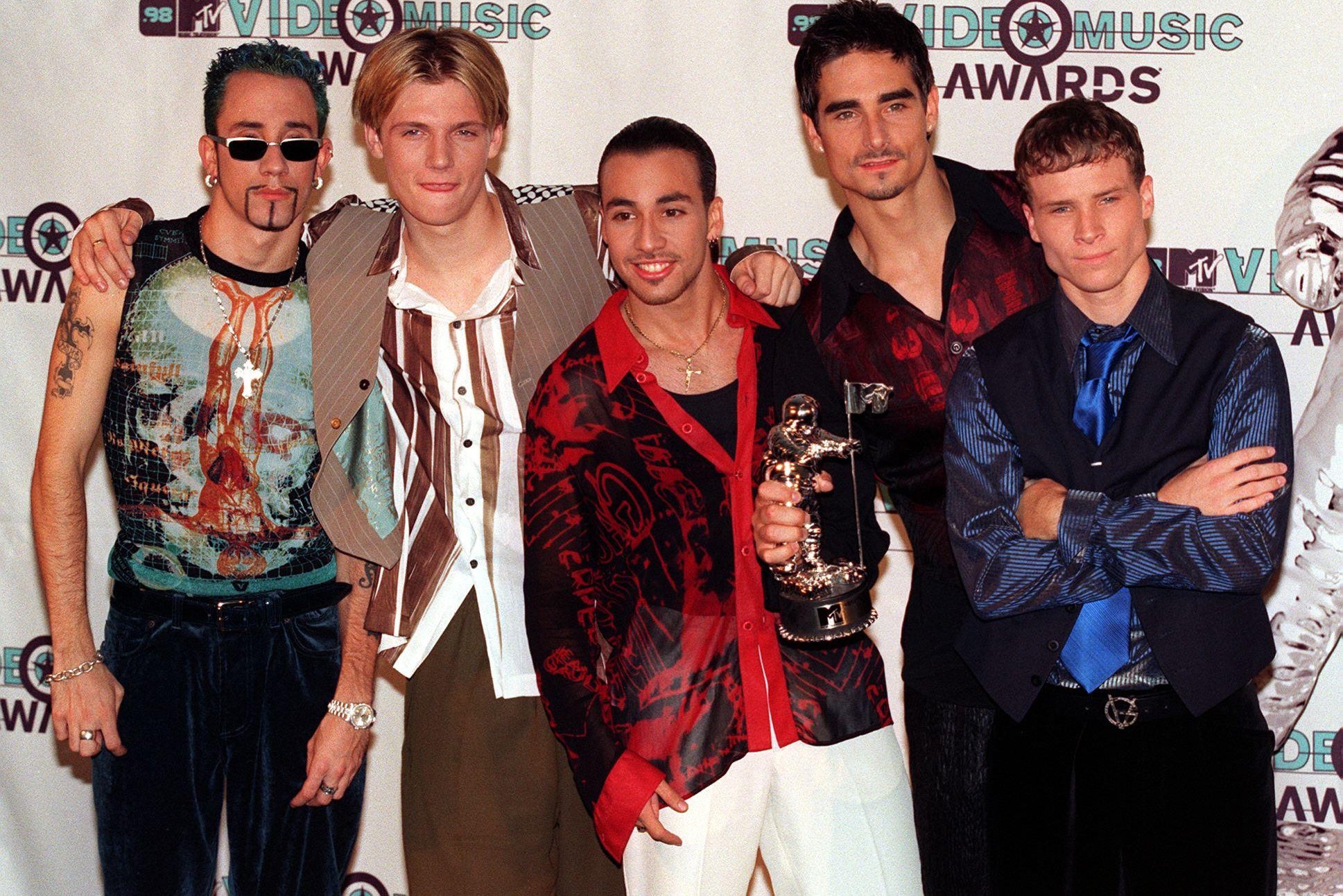 Five men pose together in front of a Video Music Awards step-and-repeat.