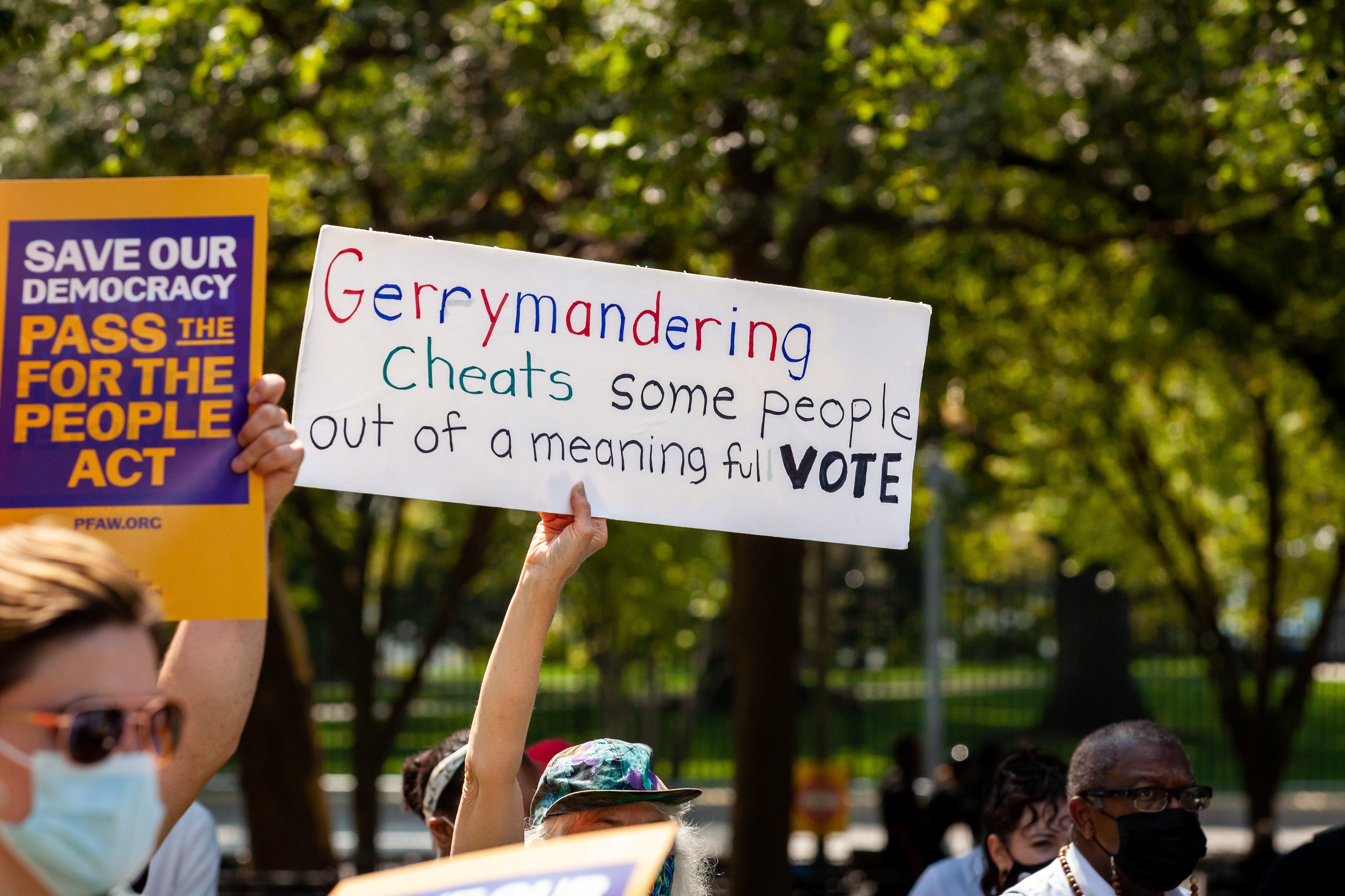 A protester holds a sign opposing gerrymandering.