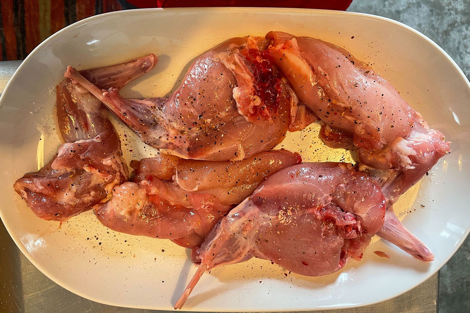 Seasoned rabbit pieces on a platter.