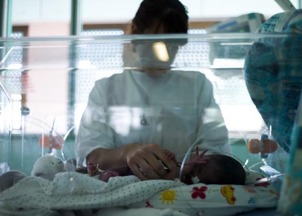 A nurse takes care of a premature baby at the maternity ward.