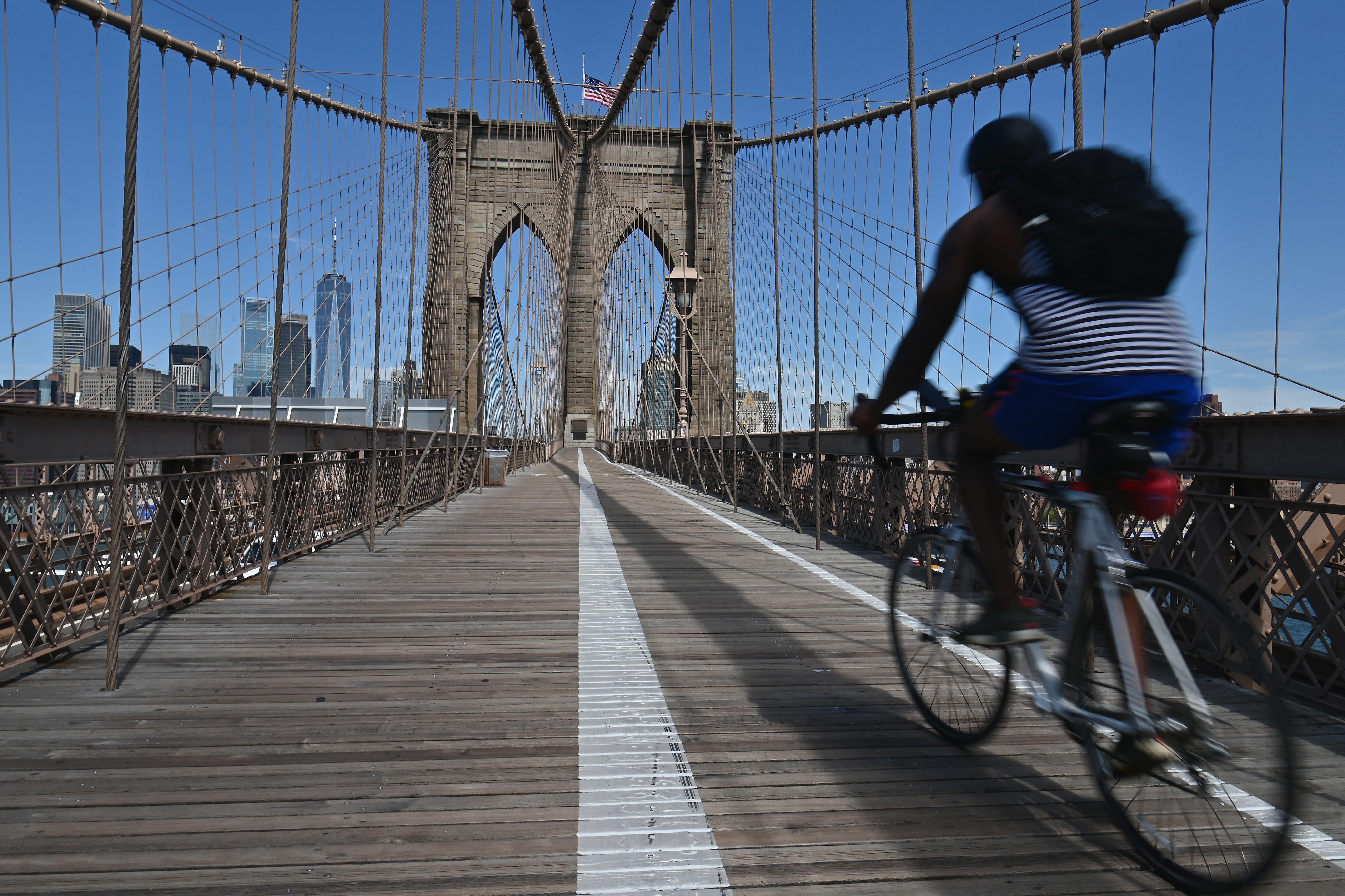 People ride bikes to commute over the Brooklyn Bridge amid the coronavirus pandemic on August 3, 2020 in New York City. (Photo by Angela Weiss / AFP) (Photo by ANGELA WEISS/AFP via Getty Images)