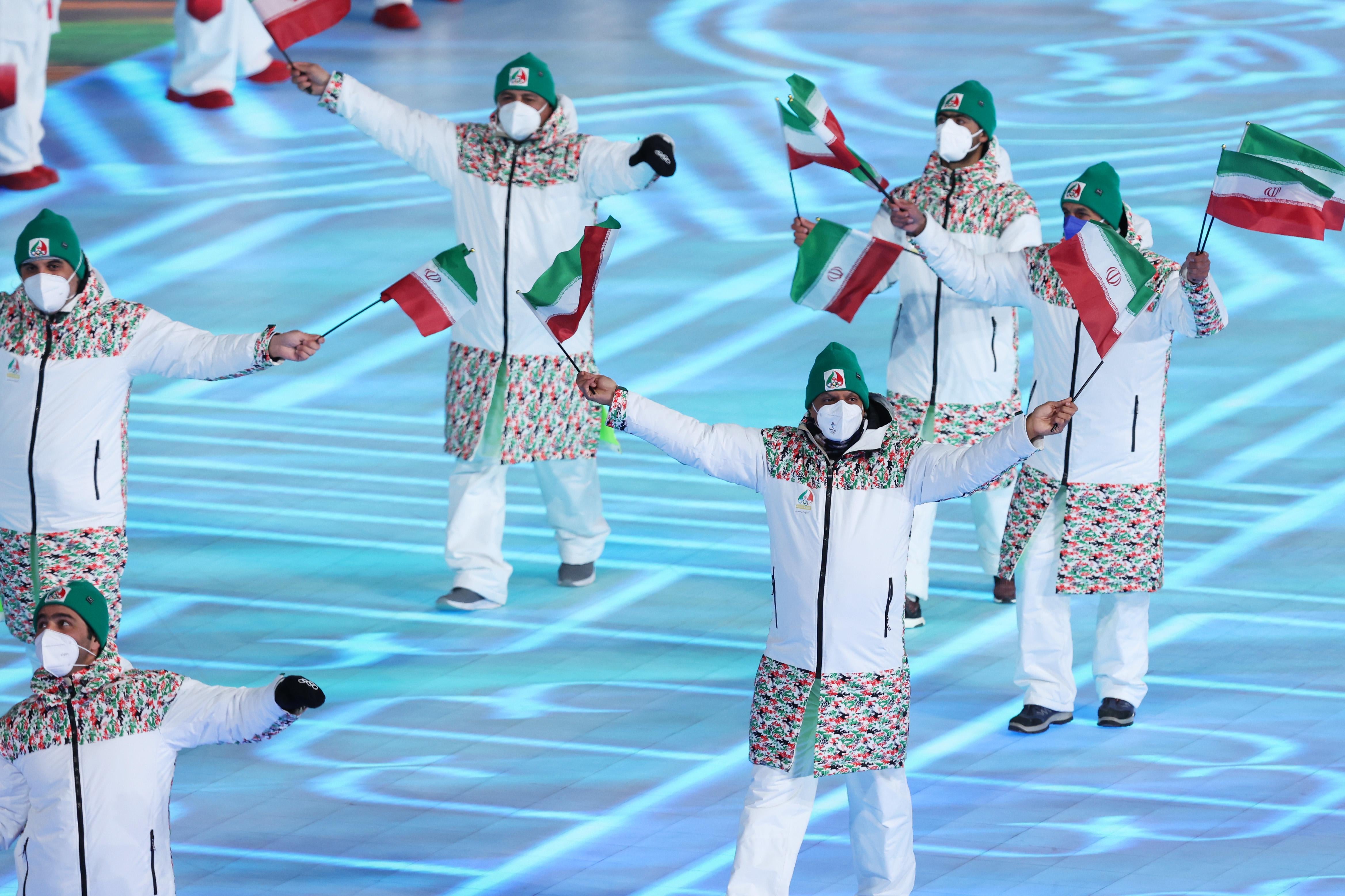 Team Iran walks with flags as a group.
