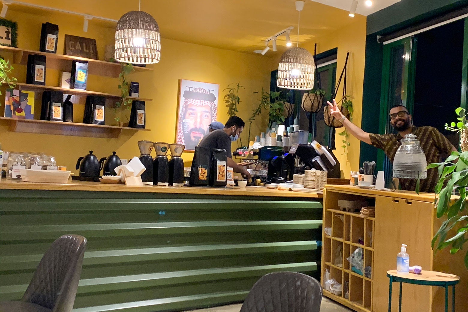 Employees behind the coffeeshop counter with a photo of Mohamed Bin Salman on the wall.