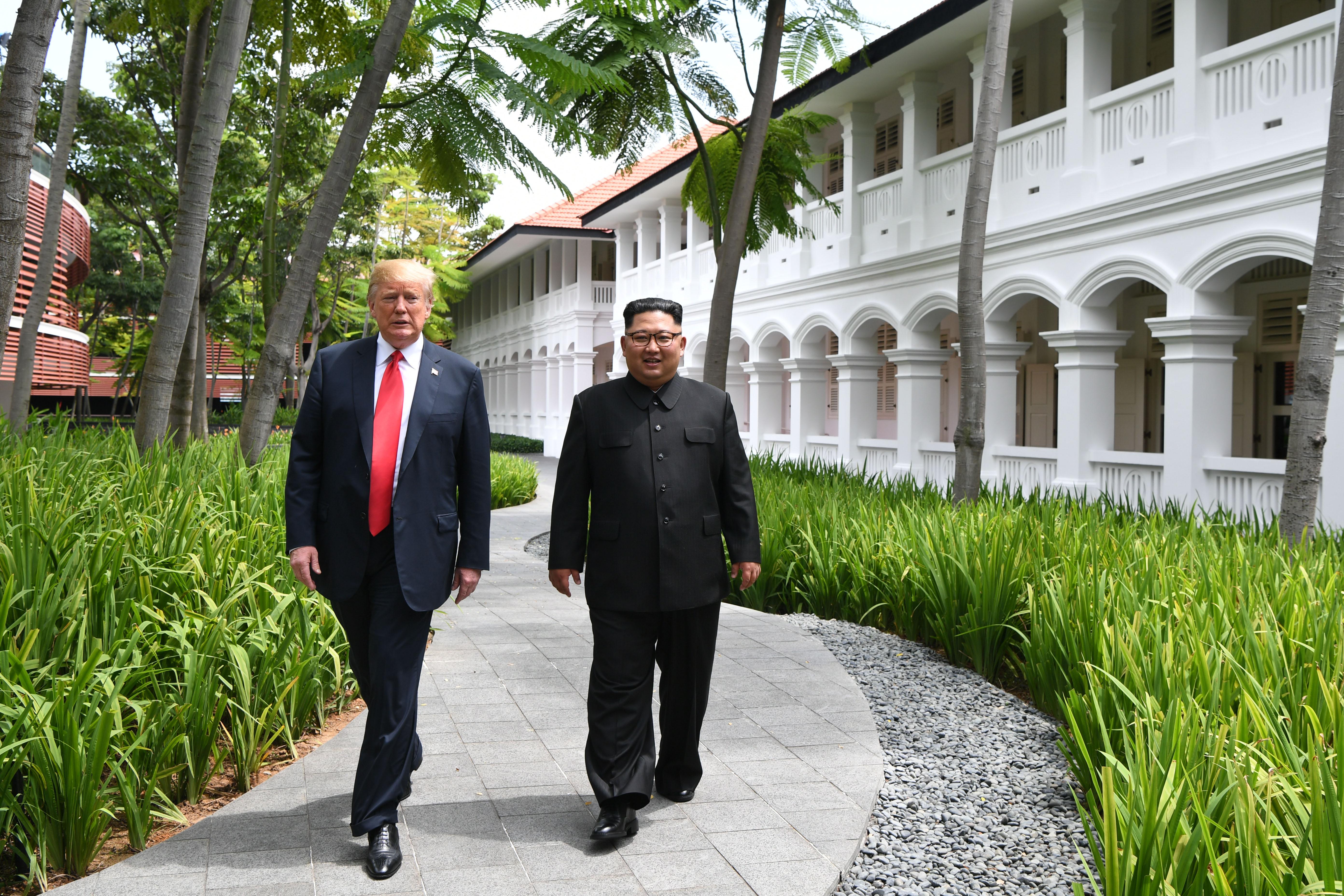 North Korea's leader Kim Jong Un (R) walks with US President Donald Trump (L) during a break in talks at their historic US-North Korea summit, at the Capella Hotel on Sentosa island in Singapore on June 12, 2018. - Donald Trump and Kim Jong Un became on June 12 the first sitting US and North Korean leaders to meet, shake hands and negotiate to end a decades-old nuclear stand-off. (Photo by Anthony WALLACE / POOL / AFP)        (Photo credit should read ANTHONY WALLACE/AFP/Getty Images)