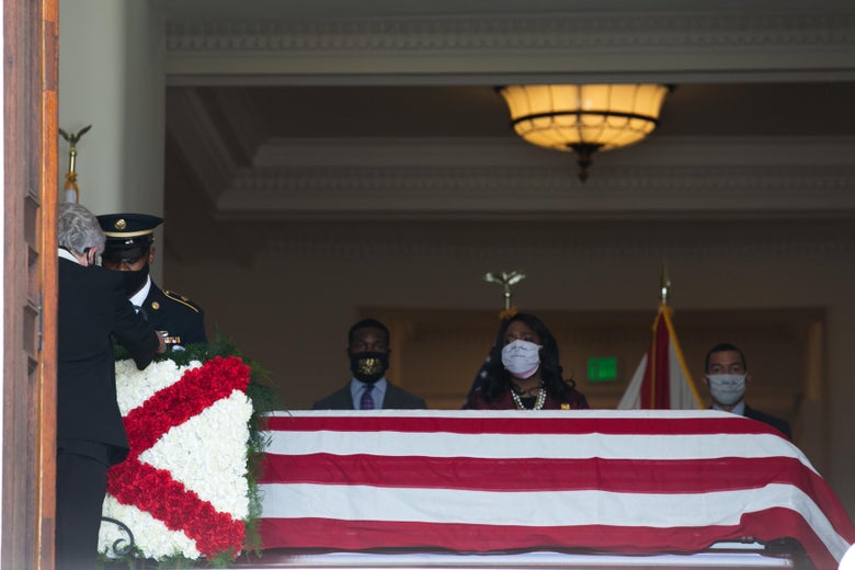 Alabama Governor Kay Ivey (left) places an Alabama flag flower arrangement in front of the casket of civil rights icon, former US Rep. John Lewis (D-GA) as he lies in state at the Alabama State Capitol on July 26, 2020 in Montgomery, Alabama.
