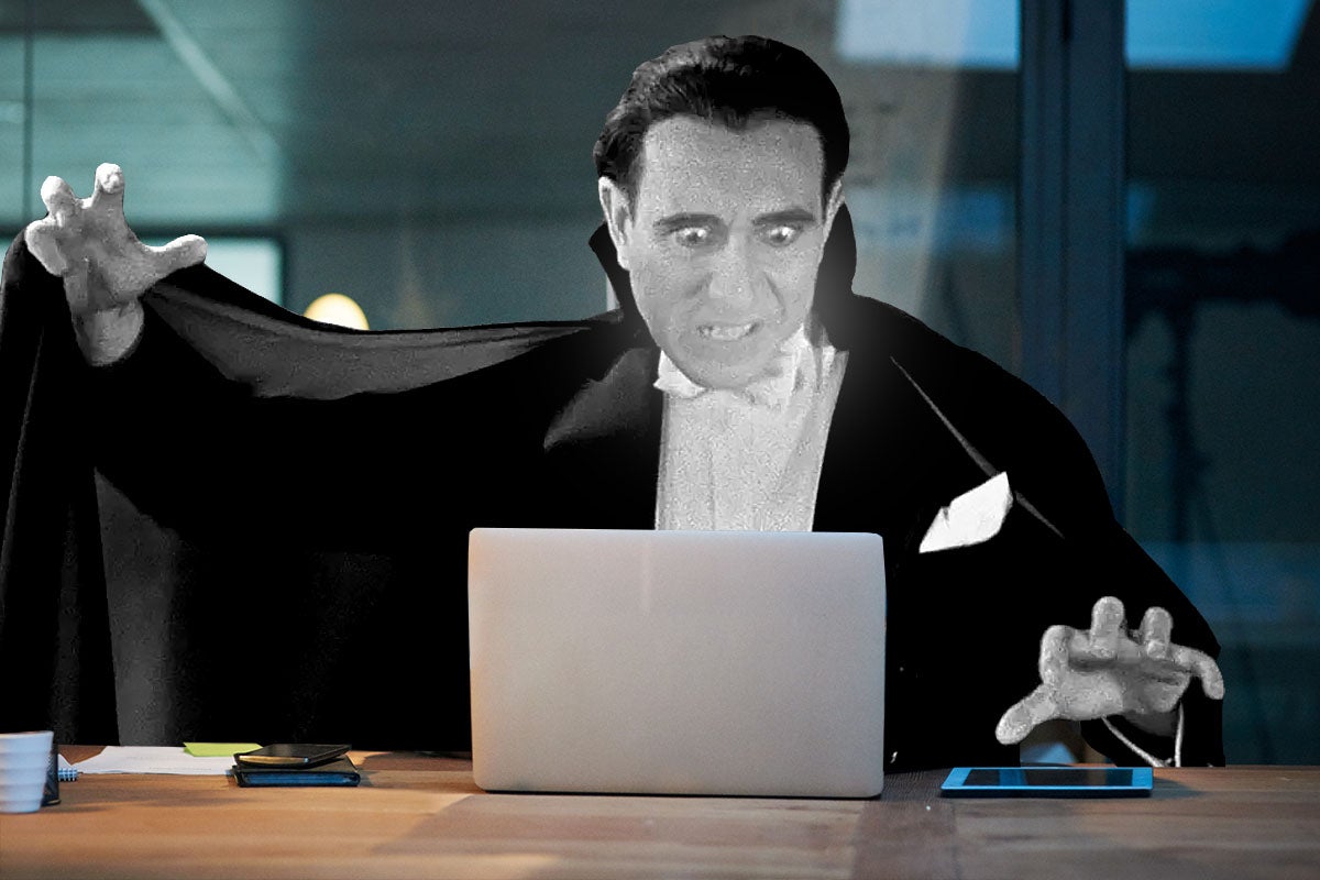 Bela Lugosi as Dracula hovering over a laptop.