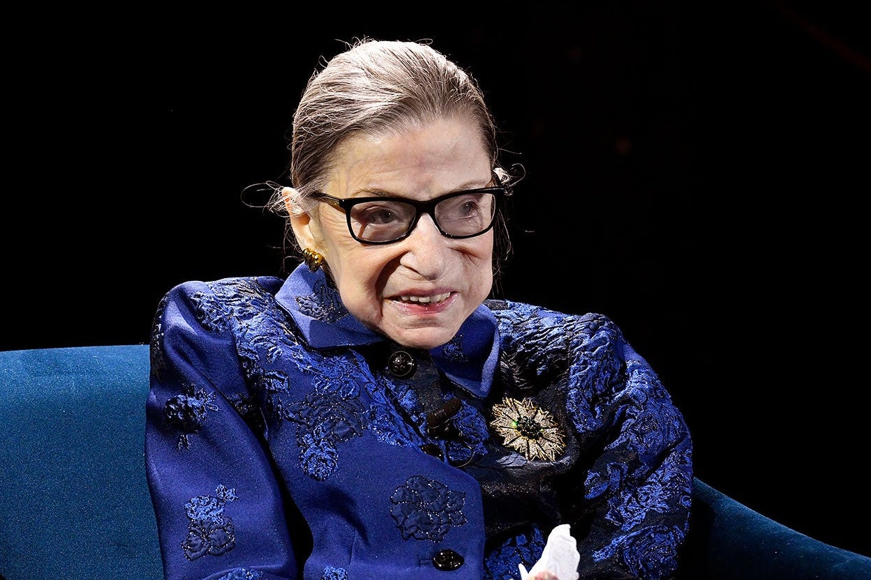 Ruth Bader Ginsburg seated while speaking onstage.
