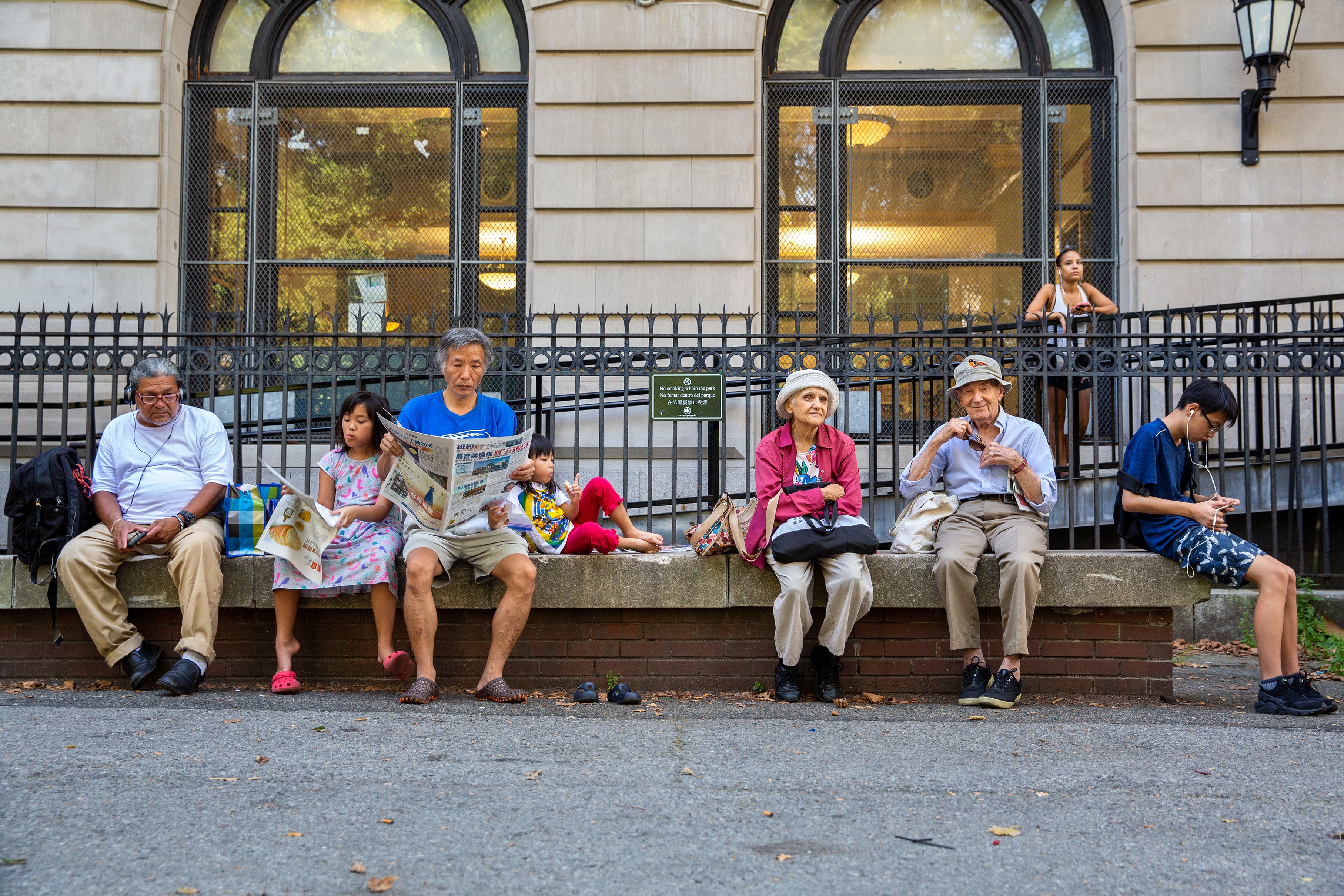 Young and old people waiting outside the library.