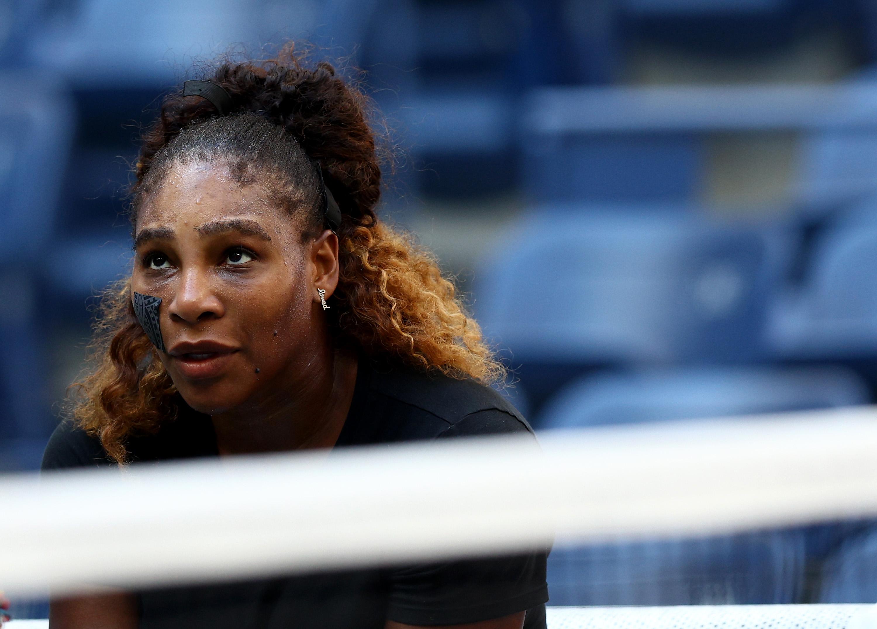 Serena crouches and peers over the net