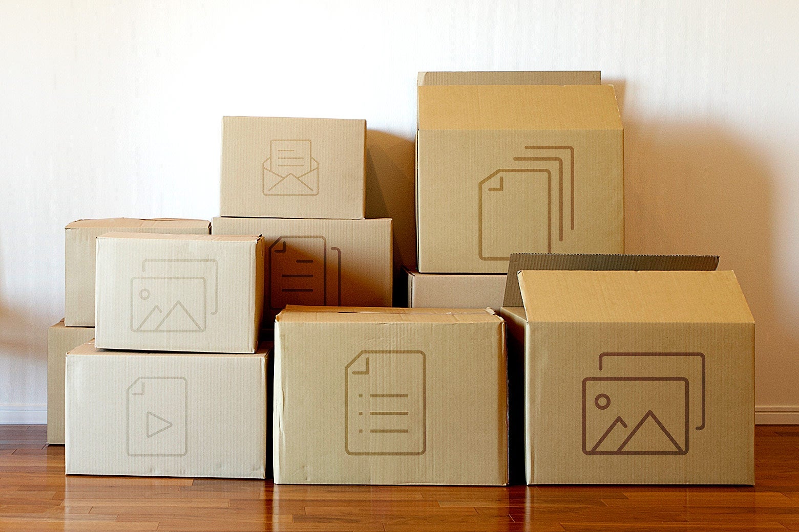 Cardboard moving boxes with app icons on them, stacked against a wall.