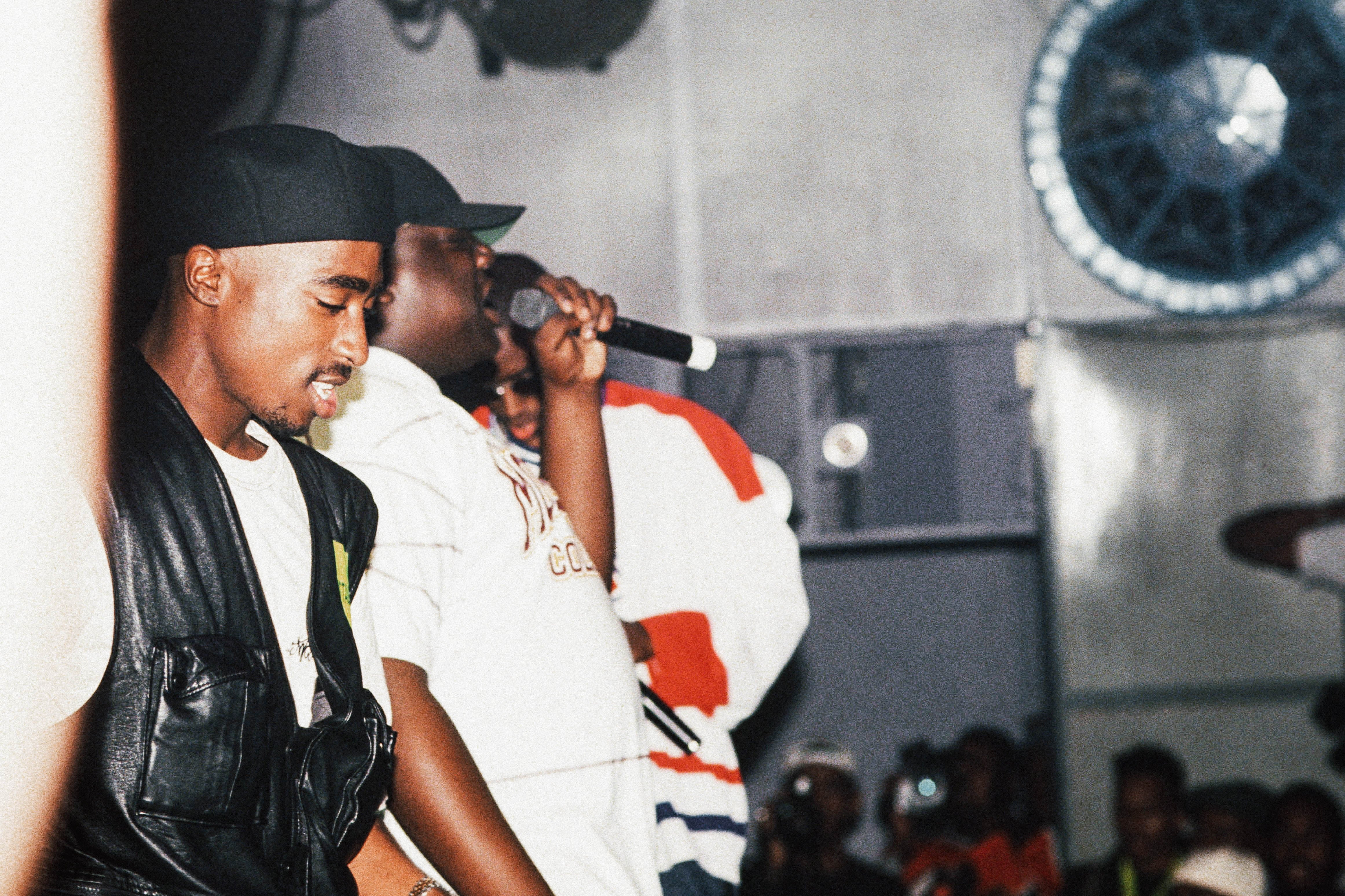 Tupac, Biggie, and Puffy onstage in front of a crowd.