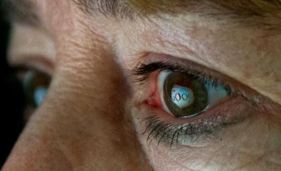 This June 25, 2013, photo illustration shows the Internet search giant Google logo reflected in a woman's eye.