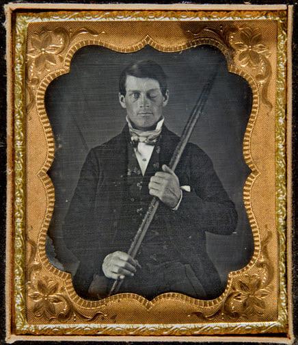 Cased-daguerreotype portrait of Phineas P. Gage holding the tamping iron which injured him.