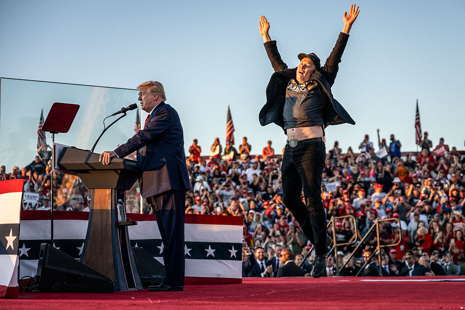 Trump speaks, Musk jumps up in the air, arms extended, exposing his belly.