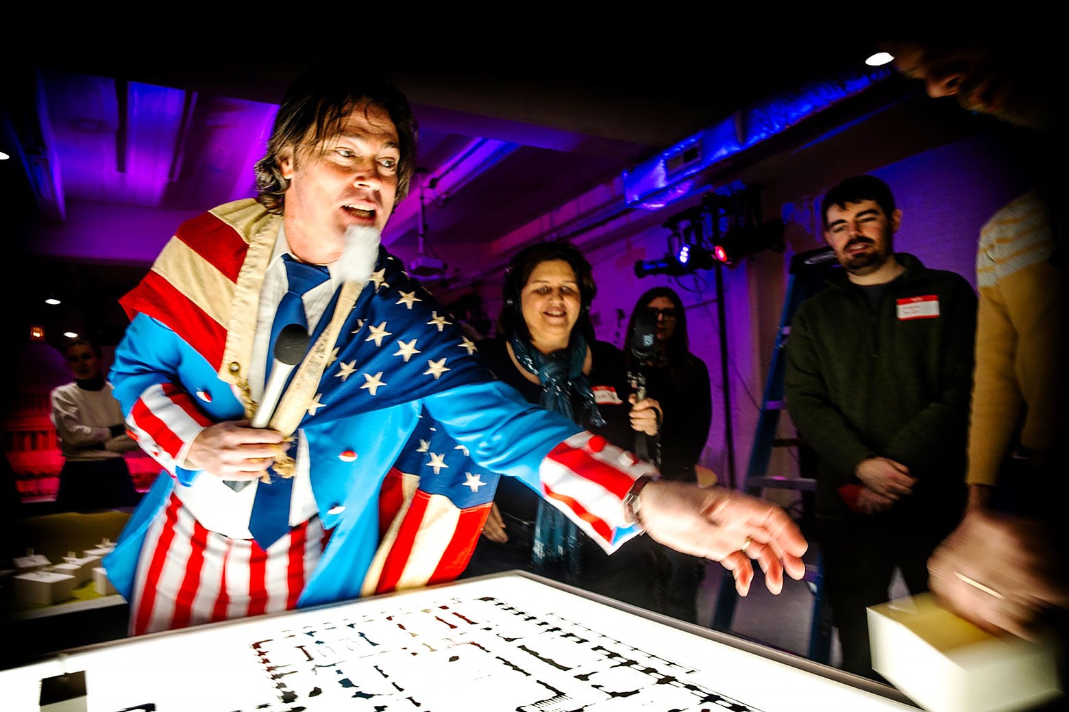 An emcee dressed as Uncle Sam points at the game board.