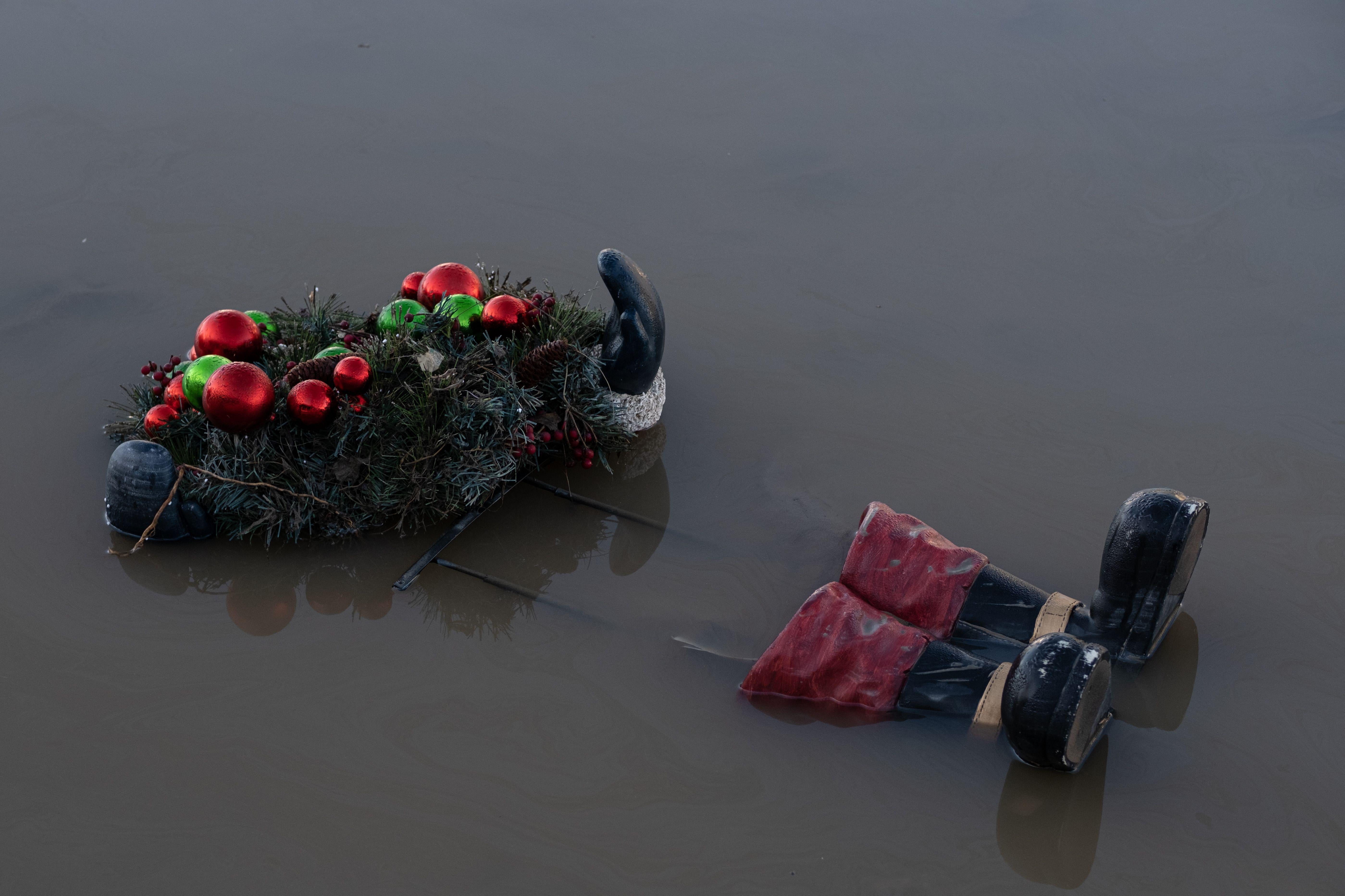 A wreath seen on top of a floating skeleton of a Santa Clause figure, whose glove and boots are still visible