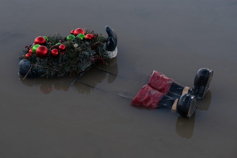 A wreath seen on top of a floating skeleton of a Santa Clause figure, whose glove and boots are still visible