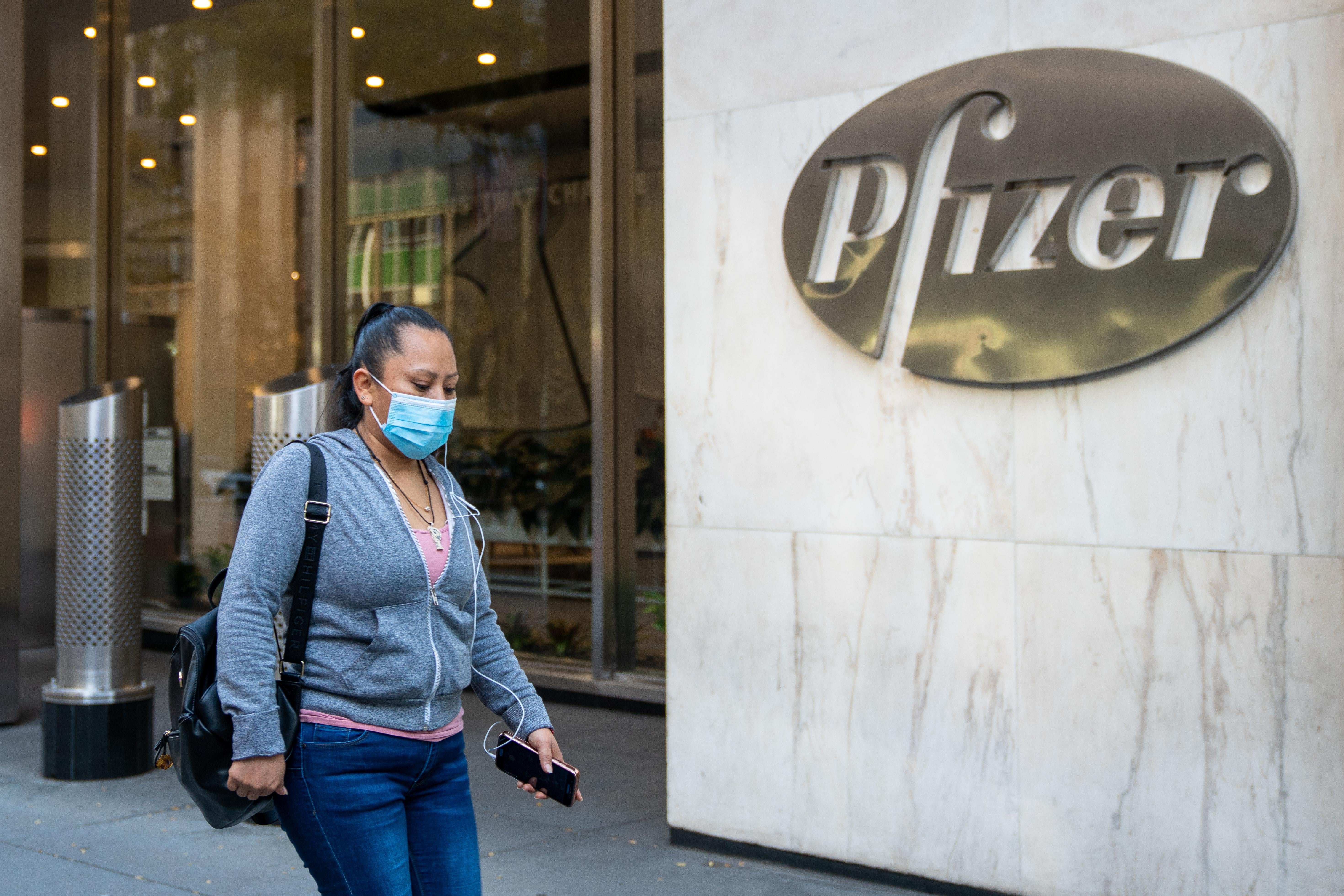 People walk by the Pfizer headquarters.