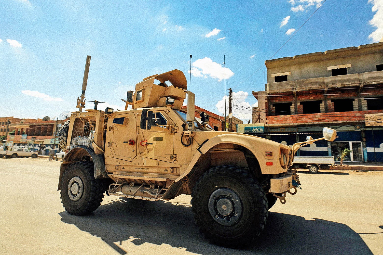 Vehicles of the U.S.-led coalition battling the Islamic State group patrol the town of Rmelane.