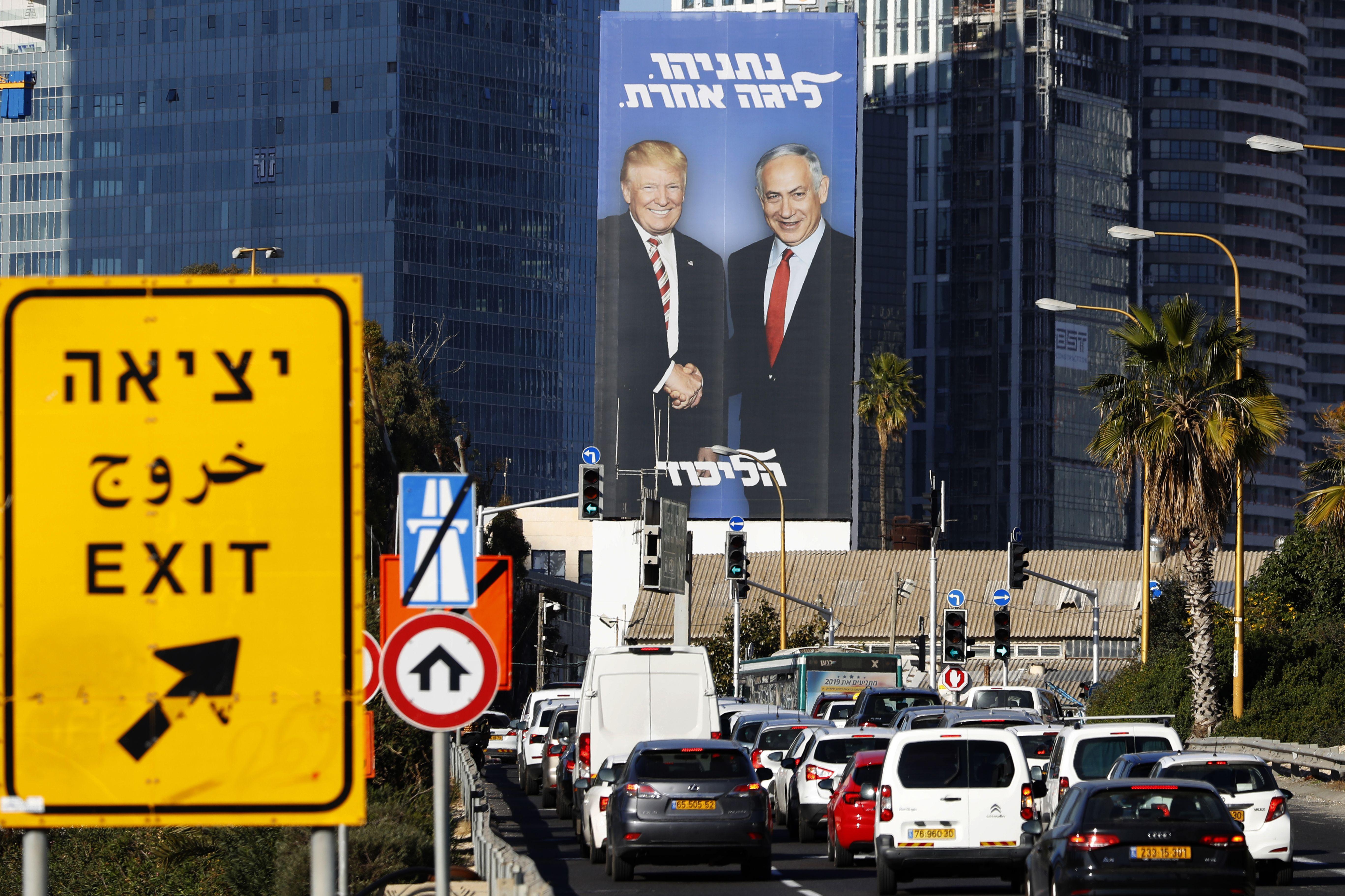 A picture taken on February 3, 2019 in Tel Aviv shows a giant election billboard of Israeli Prime Minister Benjamin Netanyahu and U.S. President Donald Trump shaking hands. 