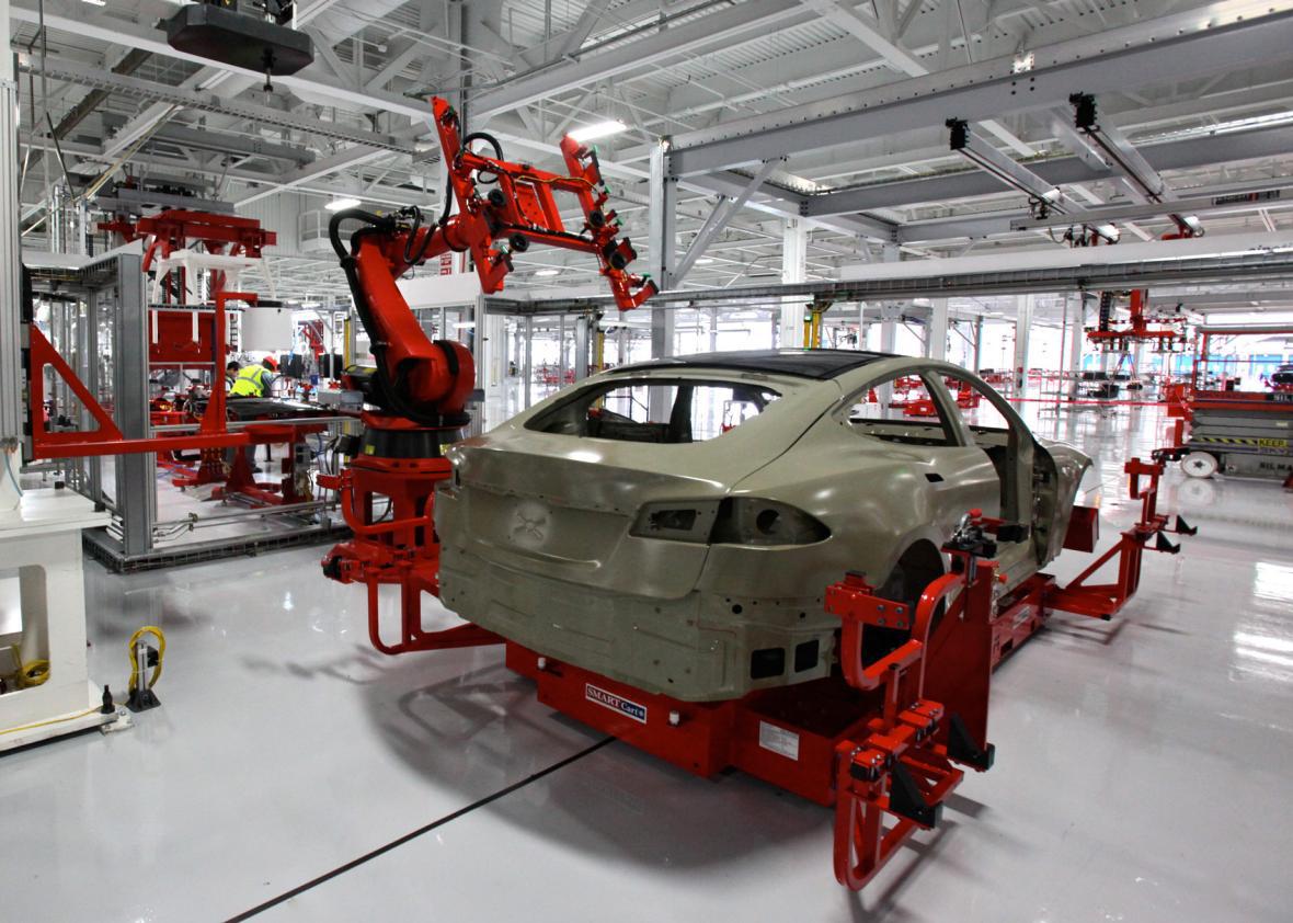 Tesla factory where a robot installs the laminated glass roof on a Model S.