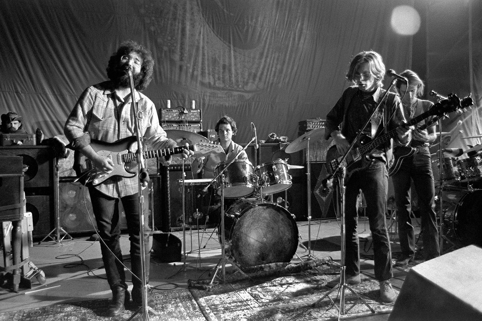 An archival black-and-white photo of the Grateful Dead performing onstage.