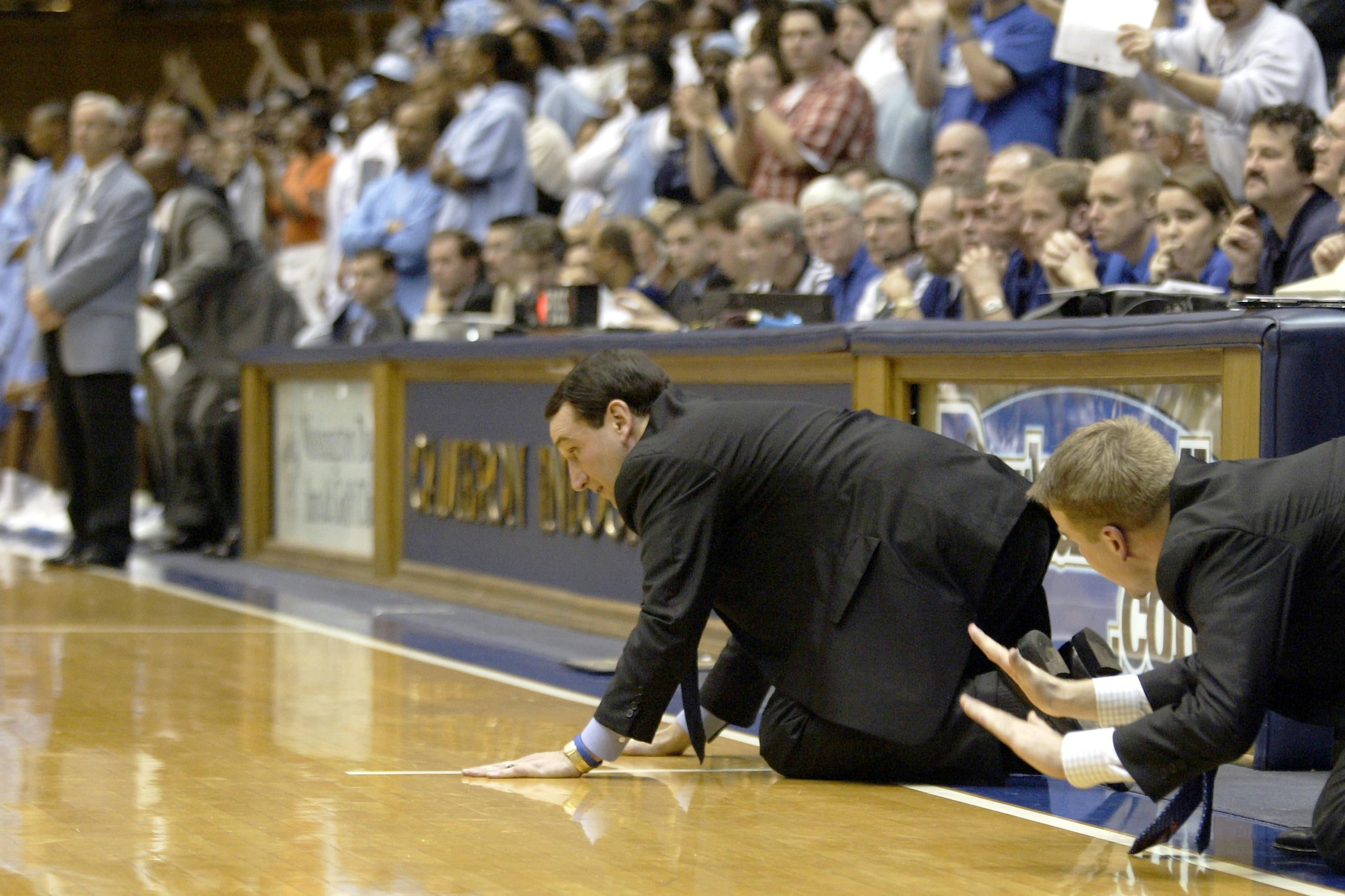DURHAM, NC - FEBRUARY 9:  Head coach Mike Krzyzewski and assistant coach Steve Wojciechowski (R) of the Duke Blue Devils slap the floor to signal defense during their game against the North Carolina Tar Heels at Cameron Indoor Stadium on February 9, 2005 in Durham, North Carolina. Duke defeated North Carolina 71-70.  (Photo by Craig Jones/Getty Images)