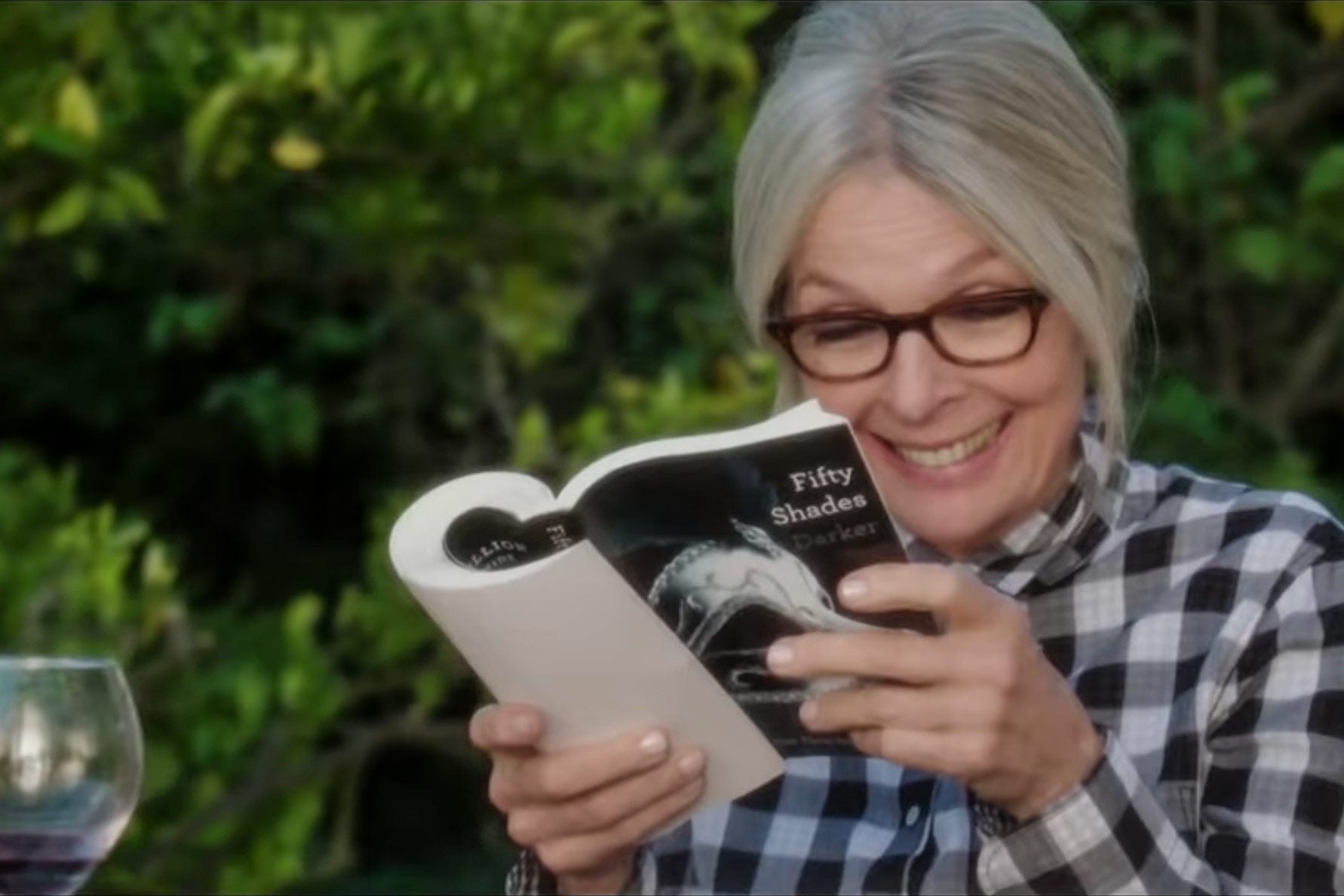 Diane Keaton grins while reading Fifty Shades of Grey in the movie Book Club.