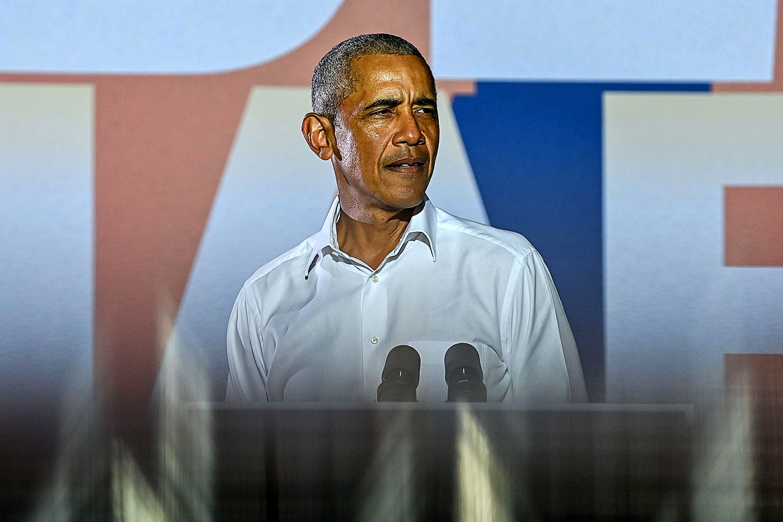 Barack Obama in a white button down, looking to the side.