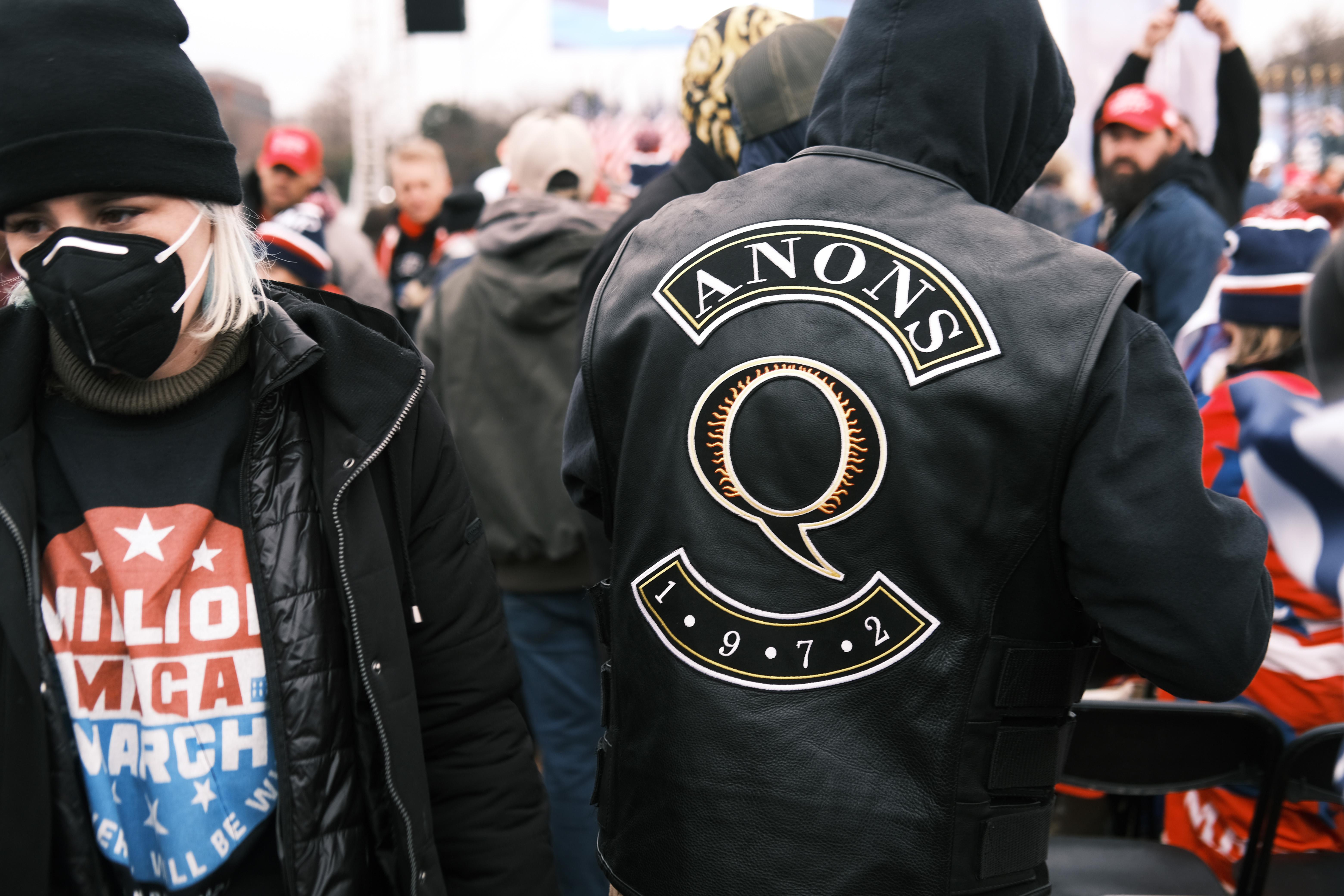 A man in a QAnon jacket at a rally.