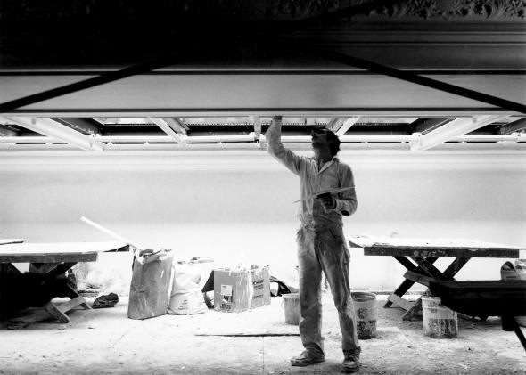 A man works on restoring the glass skylights.