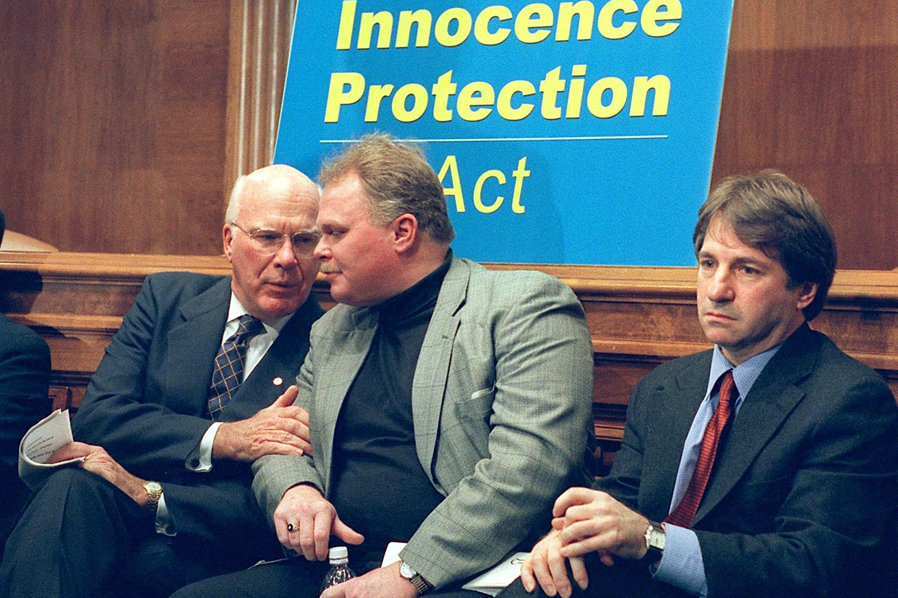 Leahy pulls Bloodsworth's arm and Scheck stares straight ahead.