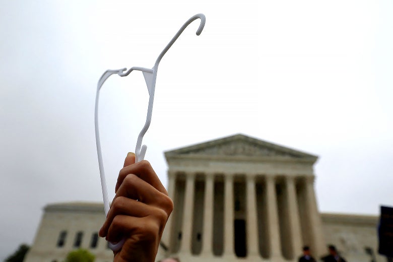 A demonstrator holds up a clothes hanger during a protest outside the U.S. Supreme Court.