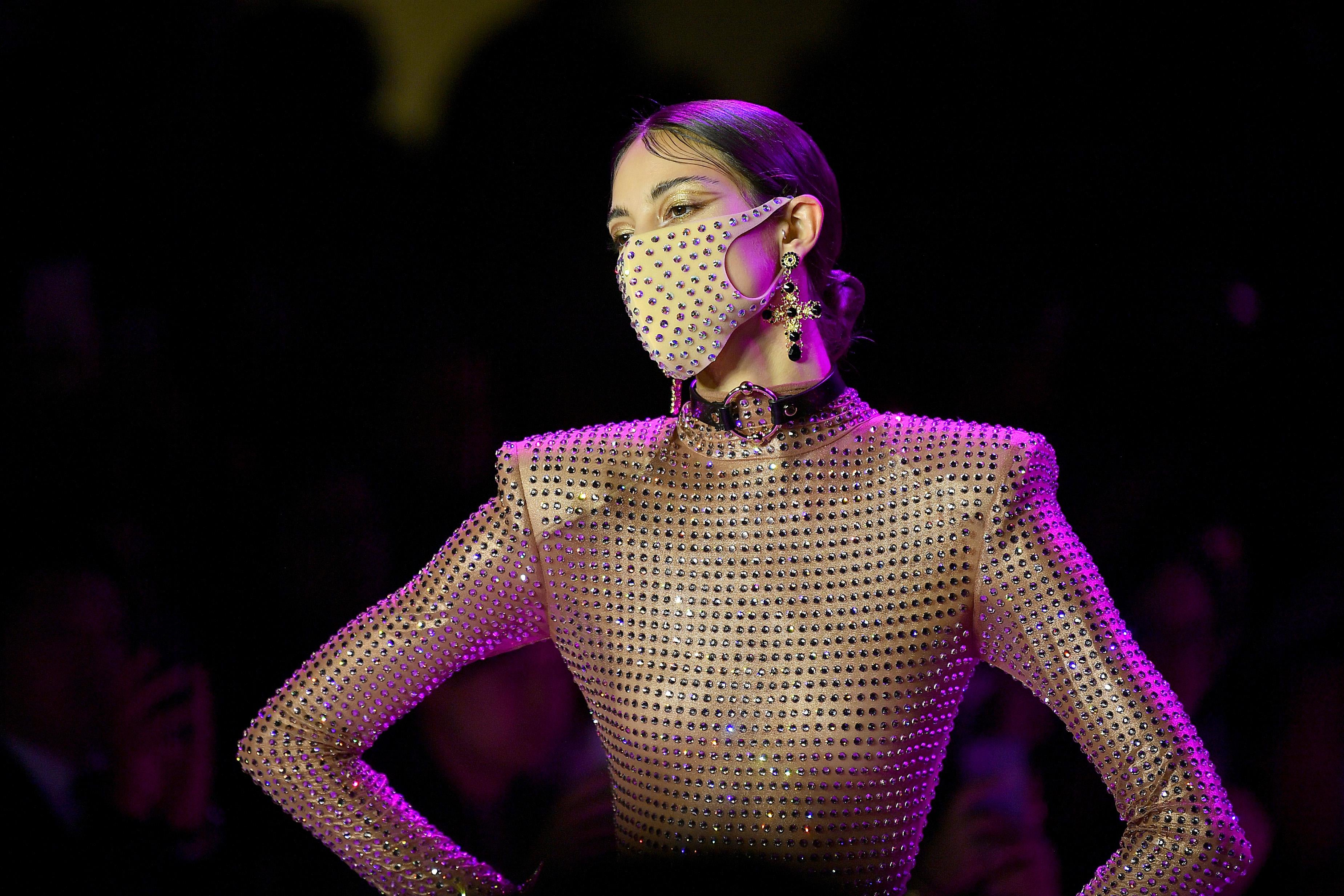 a model wearing a glittery mask that matches her shirt 