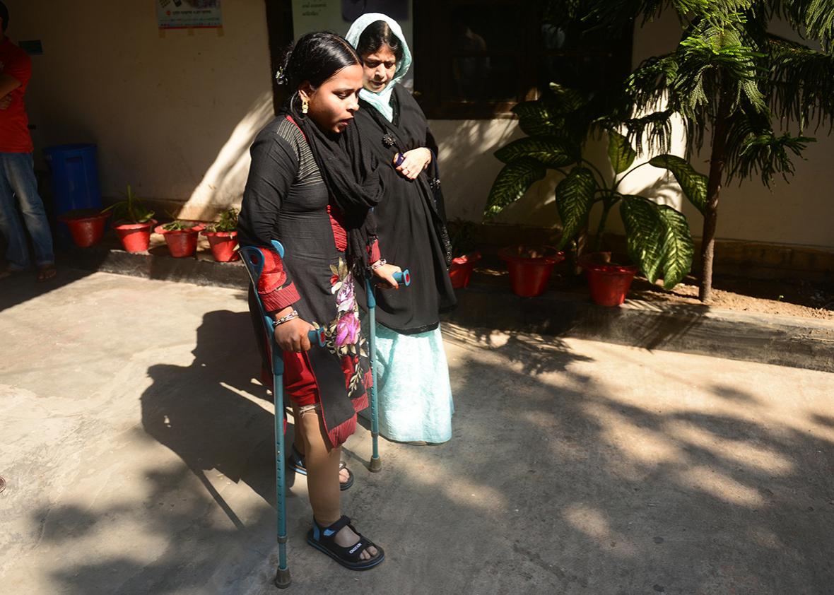 Bangladeshi garment worker Rebeka, who worked at the Rana Plaza, walks with her prosthetic legs at a hospital in Dhaka November 23, 2013.  