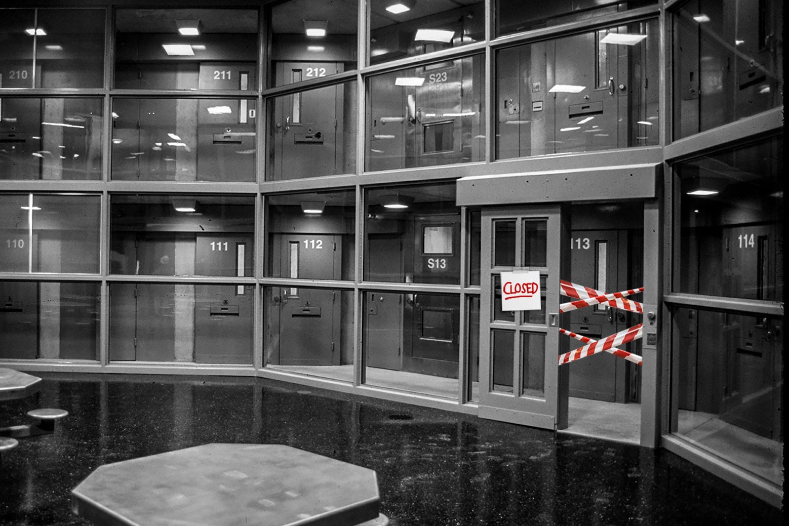 A black-and-white interior of Northern Correctional Institution's 300-bed maximum security prison, with a red-and-white "closed" sign and tape drawn over it. 