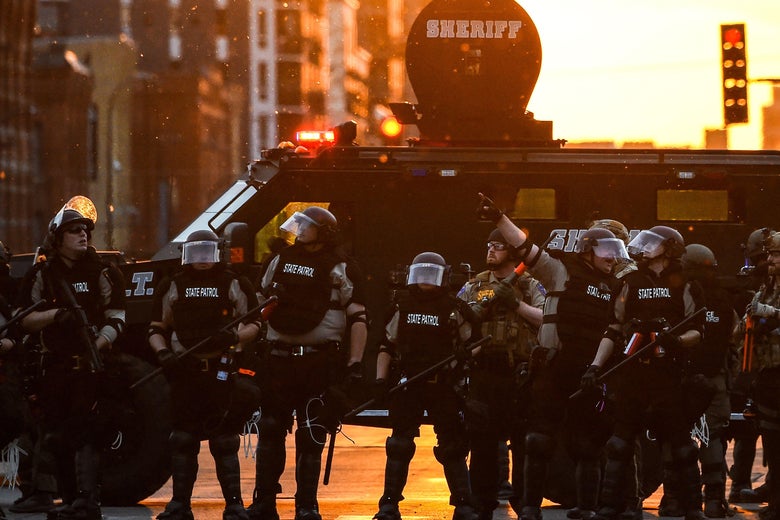 Police in massive armor and by an armored vehicle on a street in Minneapolis