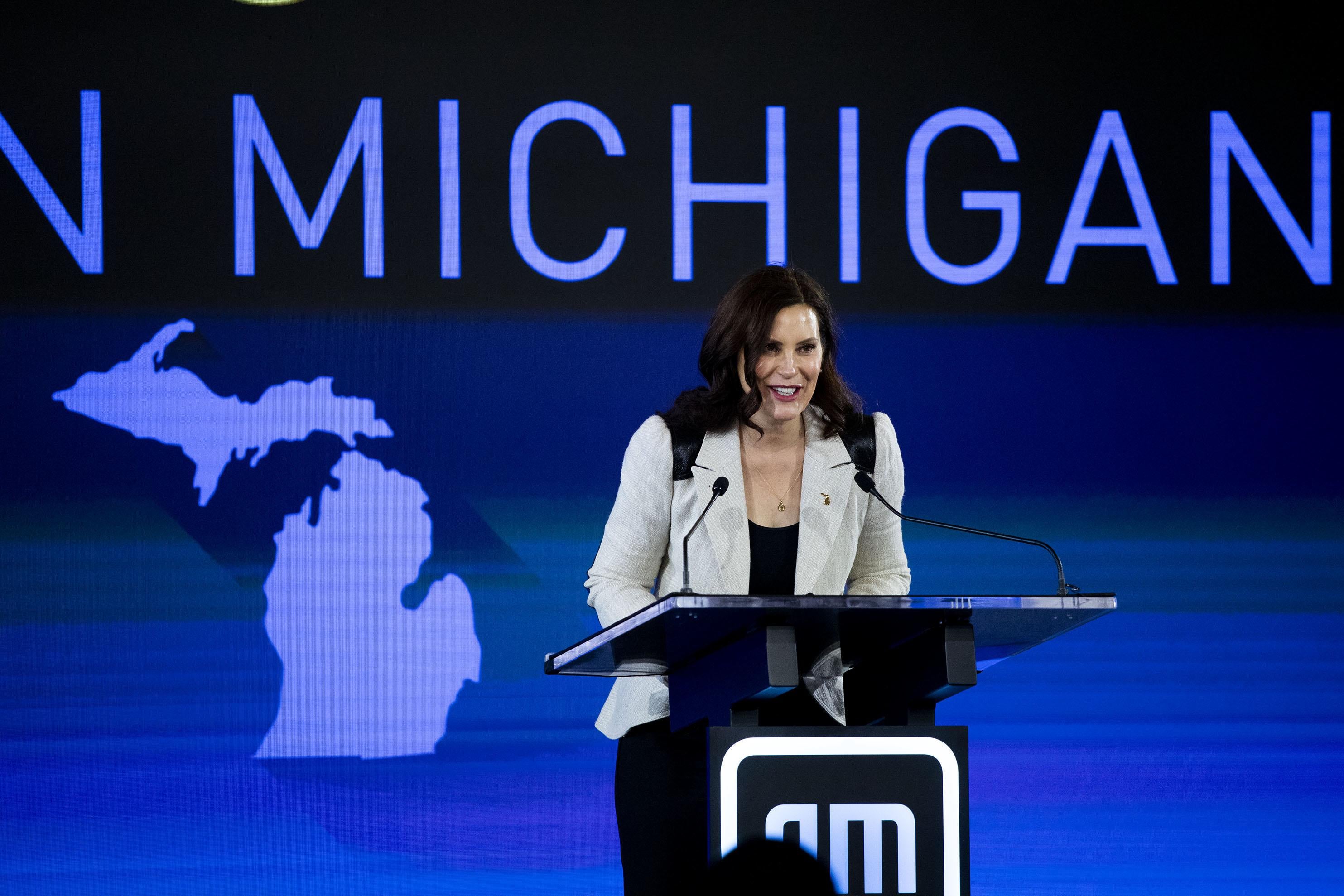 Whitmer standing in front of a banner that reads Michigan.