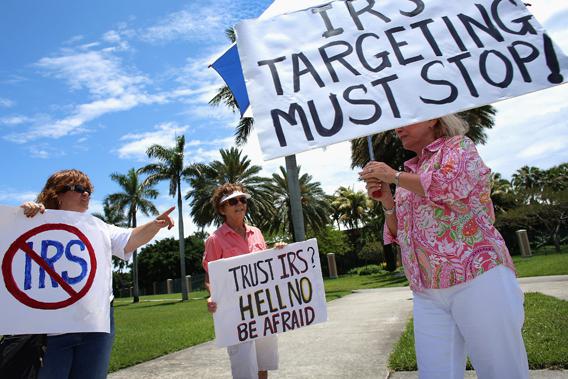 Christina King (L) and Lynne Sherrer (C) hold signs during a Tea Party Internal Revenue Service (IRS) demonstration on May 21, 2013 in West Palm Beach, Florida. 