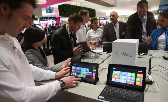 Visitors try out Windows 8 Surface tablet computers at the Microsoft stand at the 2013 CeBIT technology trade fair on March 5, 2013, in Hanover, Germany.