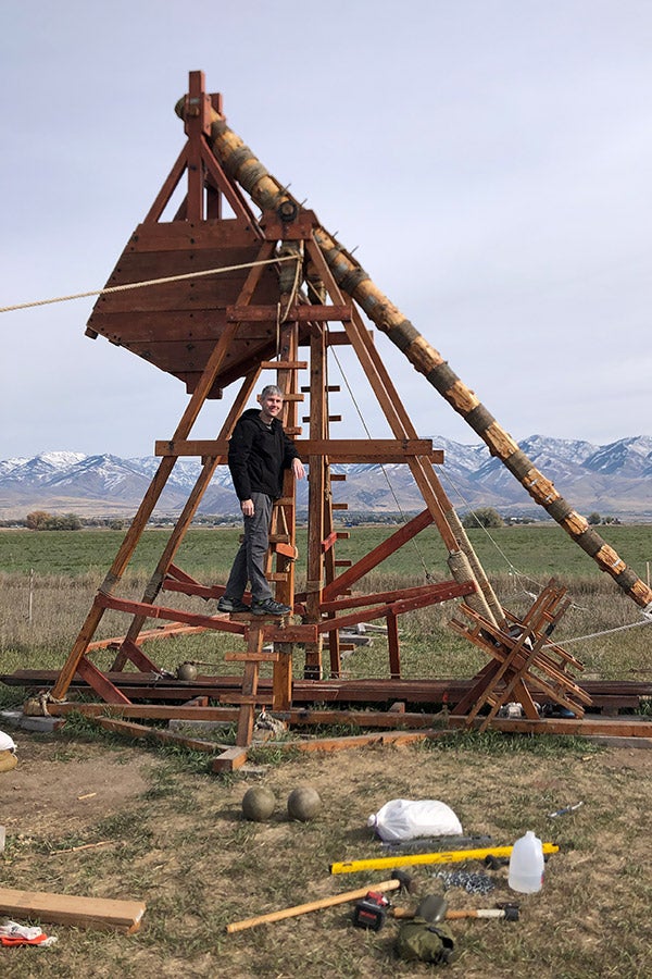 A man standing in front of a trebuchet.