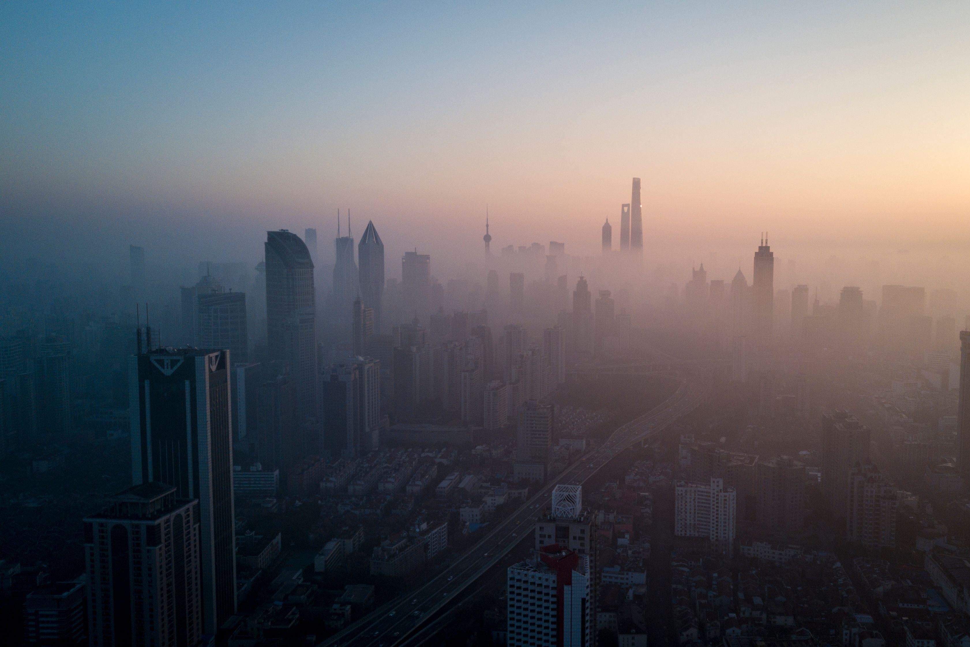 TOPSHOT - This overhead photo shows the sun rising above the skyline of Shanghai on a polluted day on February 23, 2018. (Photo by Johannes EISELE / AFP) (Photo by JOHANNES EISELE/AFP via Getty Images)