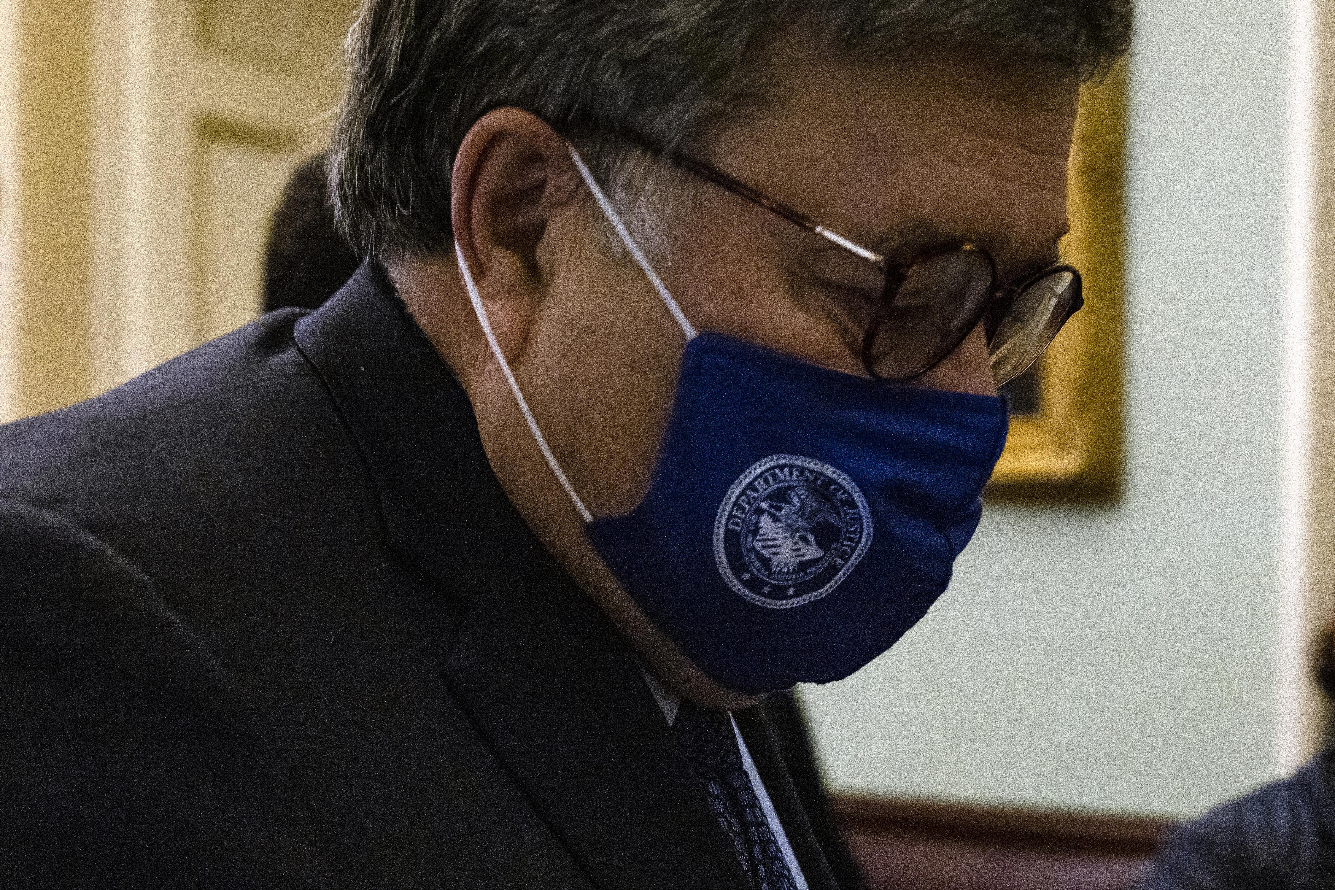 Bill Barr at the Capitol, looking down and wearing a blue mask