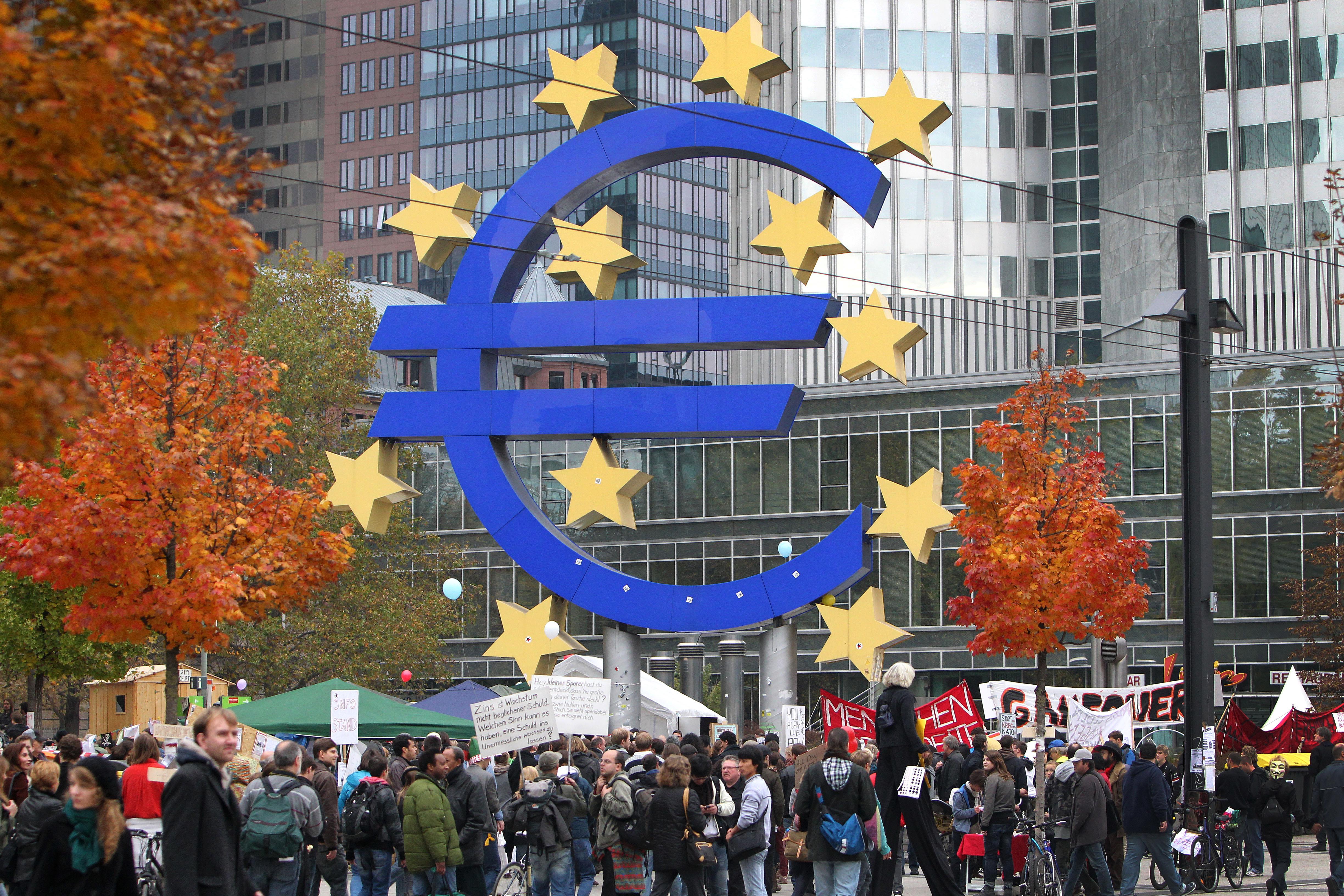 Demonstrators crowd around the euro logo in front of the European Central Bank (ECB) as they take part in a protest march as part of the 'Occupy Frankfurt' movement in Frankfurt am Main, on October 29, 2011