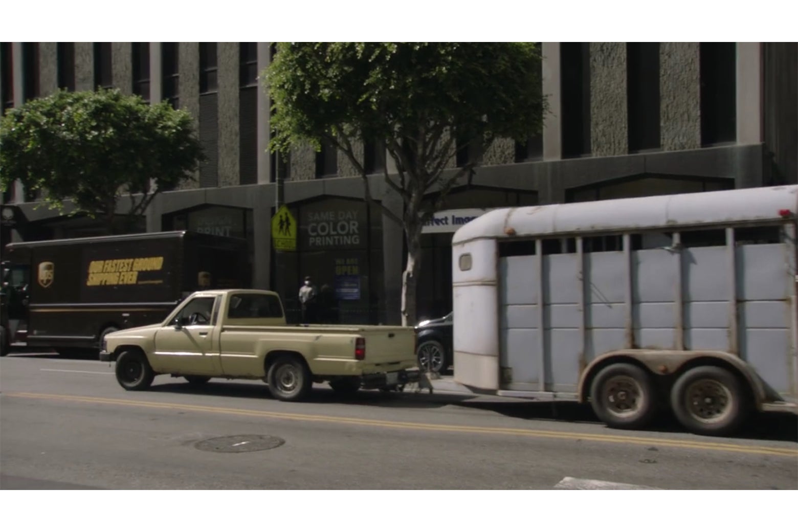 A pickup truck pulling a horse trailer down a Los Angeles street.