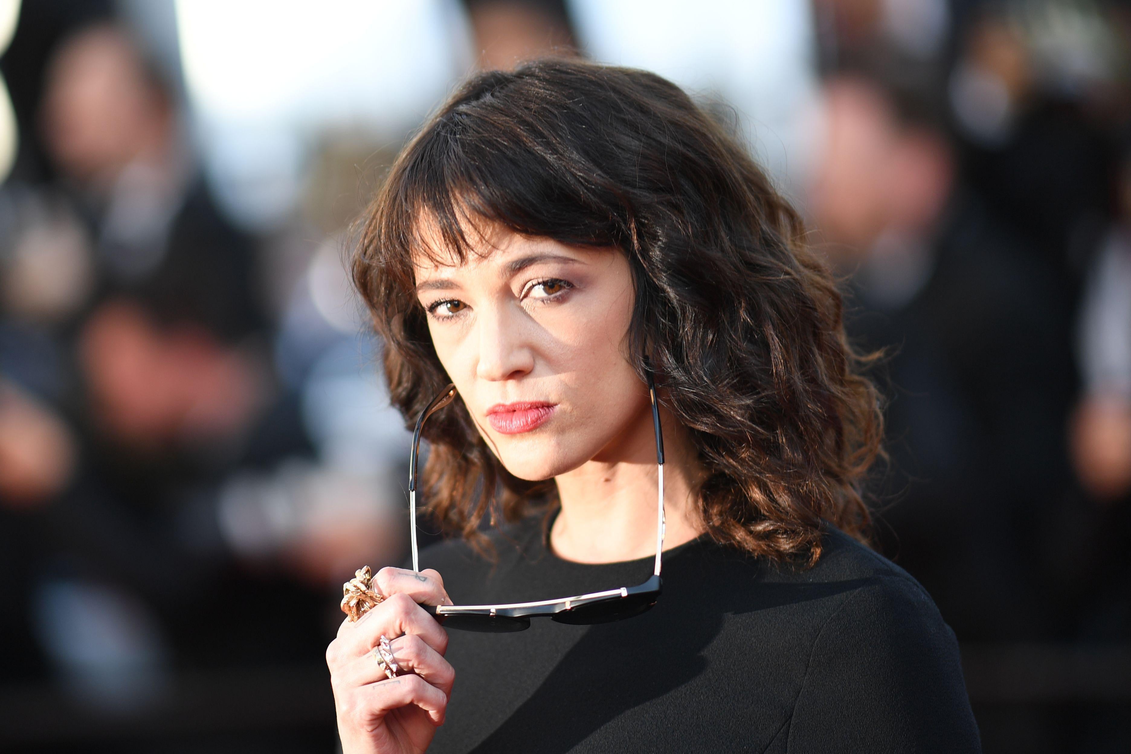 Asia Argento posing with sunglasses lowered