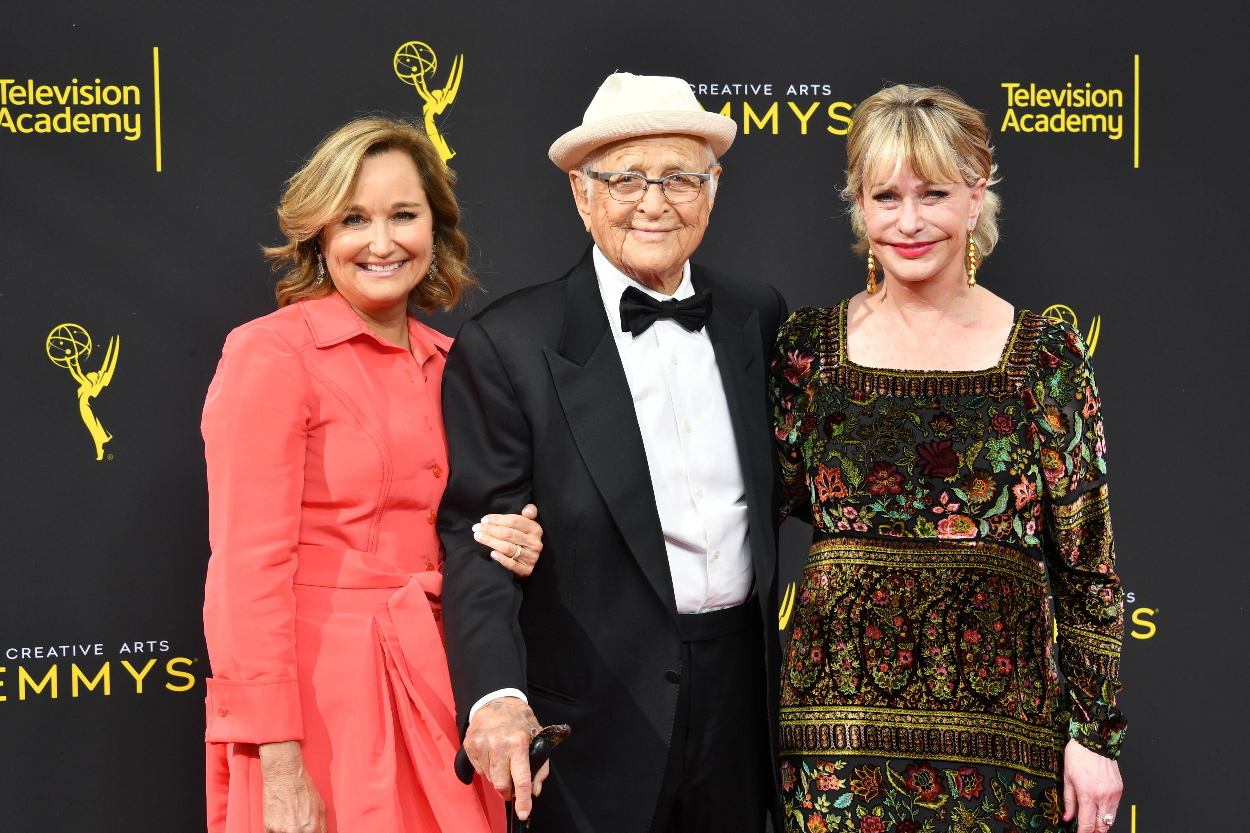 Maggie Lear, Norman Lear and Lyn Lear on a red carpet.