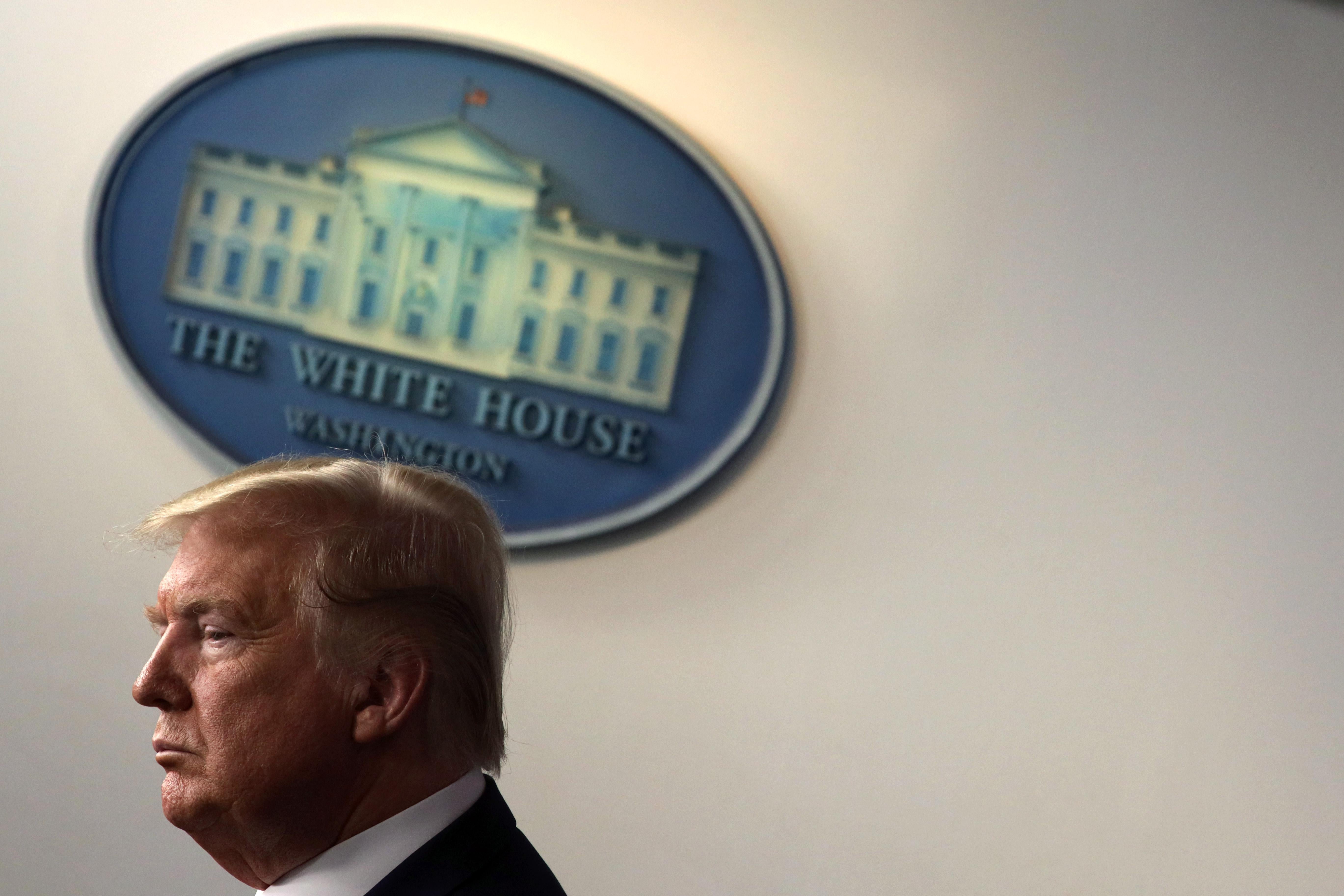 Donald Trump with a White House logo behind him.