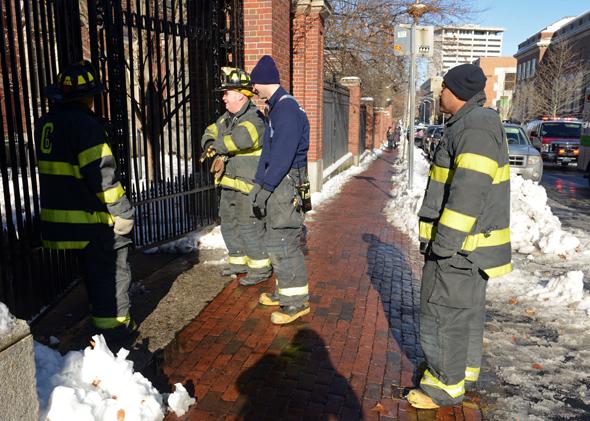 Firefighters check a locked gate on Quincy Street at Harvard University during the bomb scare